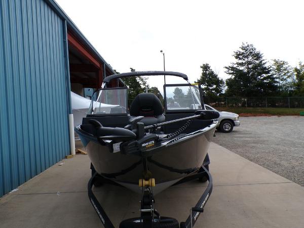 2025 Tracker Pro Guide™ V-175 Combo boat on trailer, parked near blue building.