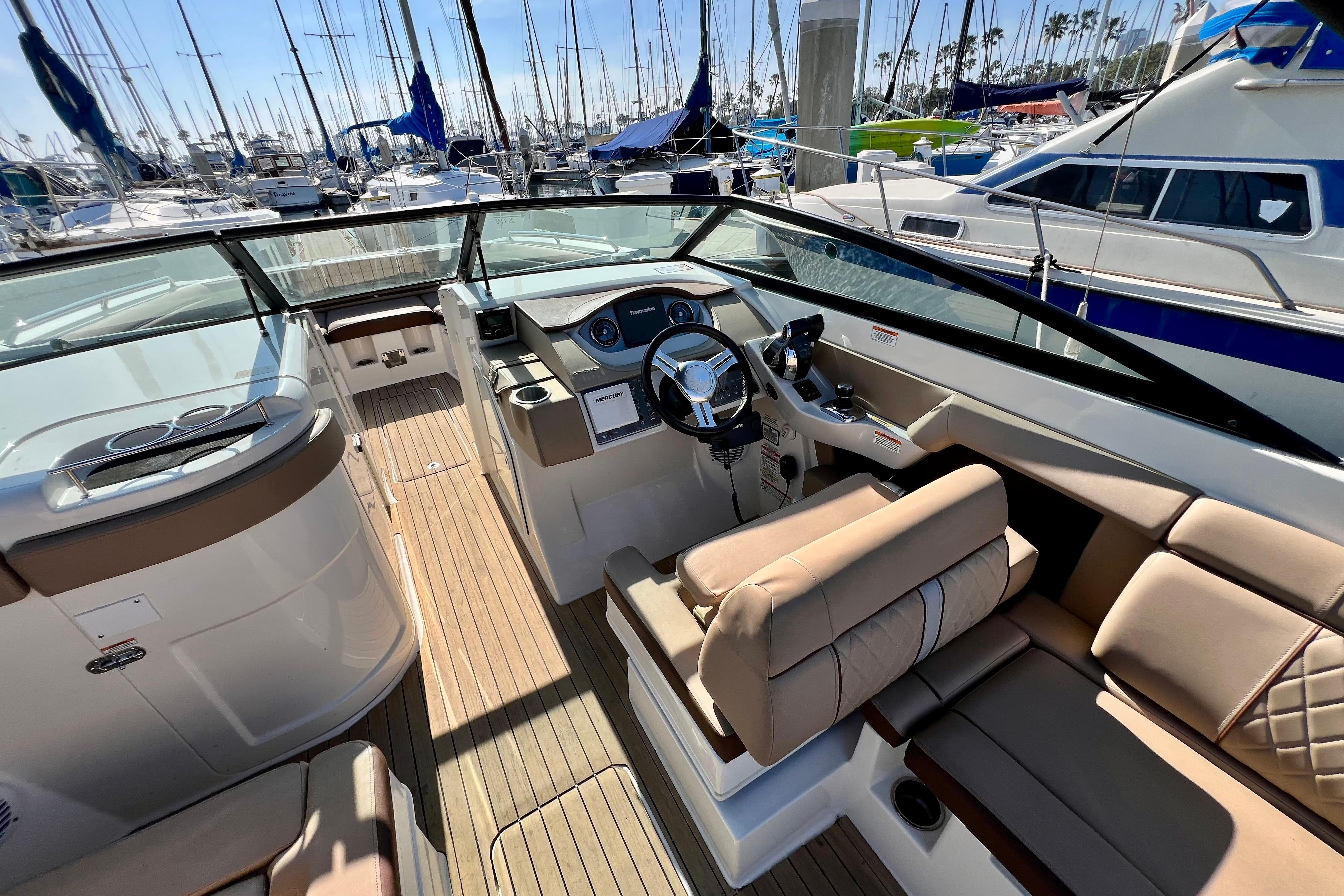 2016 Sea Ray 290 Sundeck Outboard interior with helm, seating, and marina view.