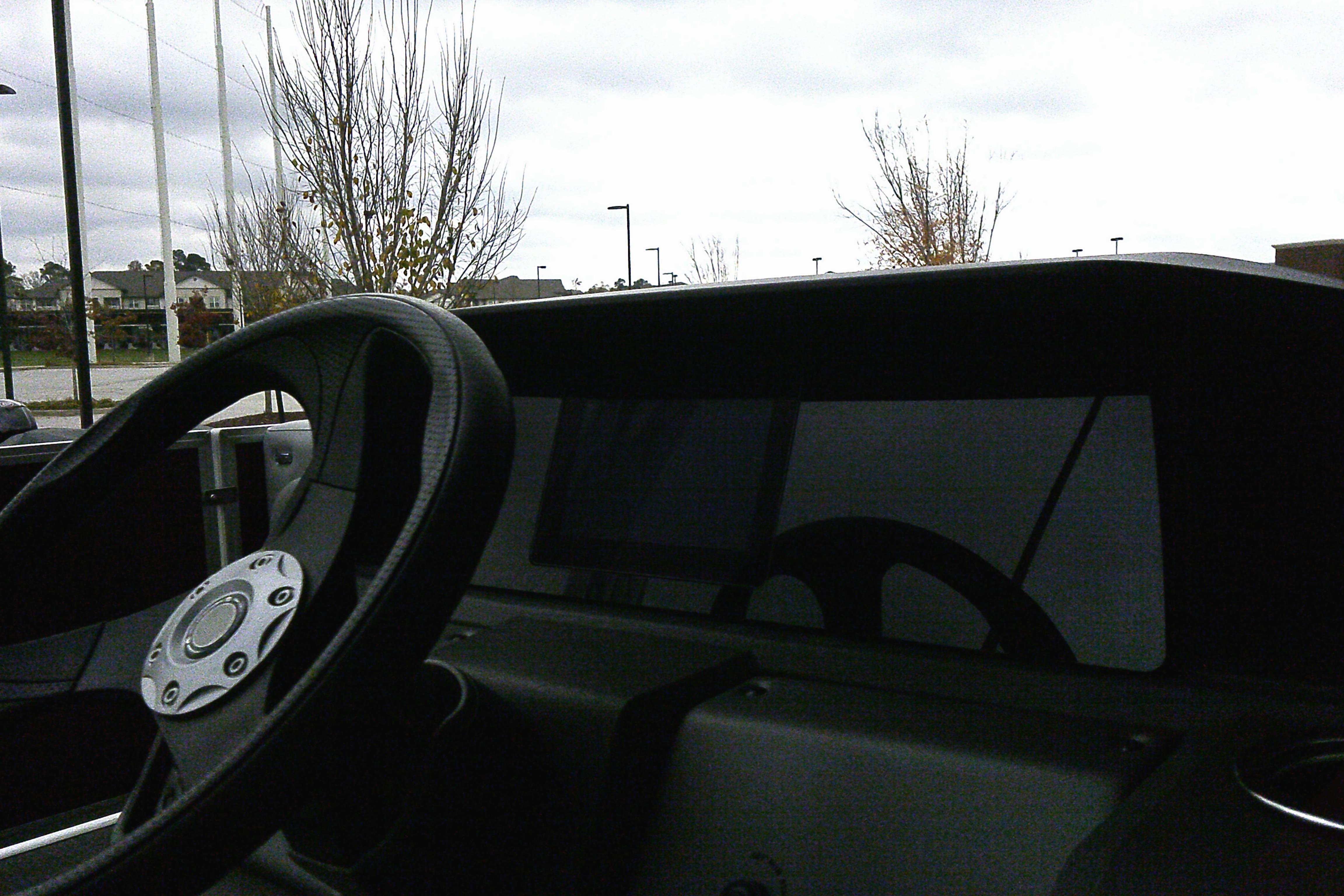 Steering wheel of 2026 Sun Tracker Party Barge 18 DLX boat, outdoor setting.