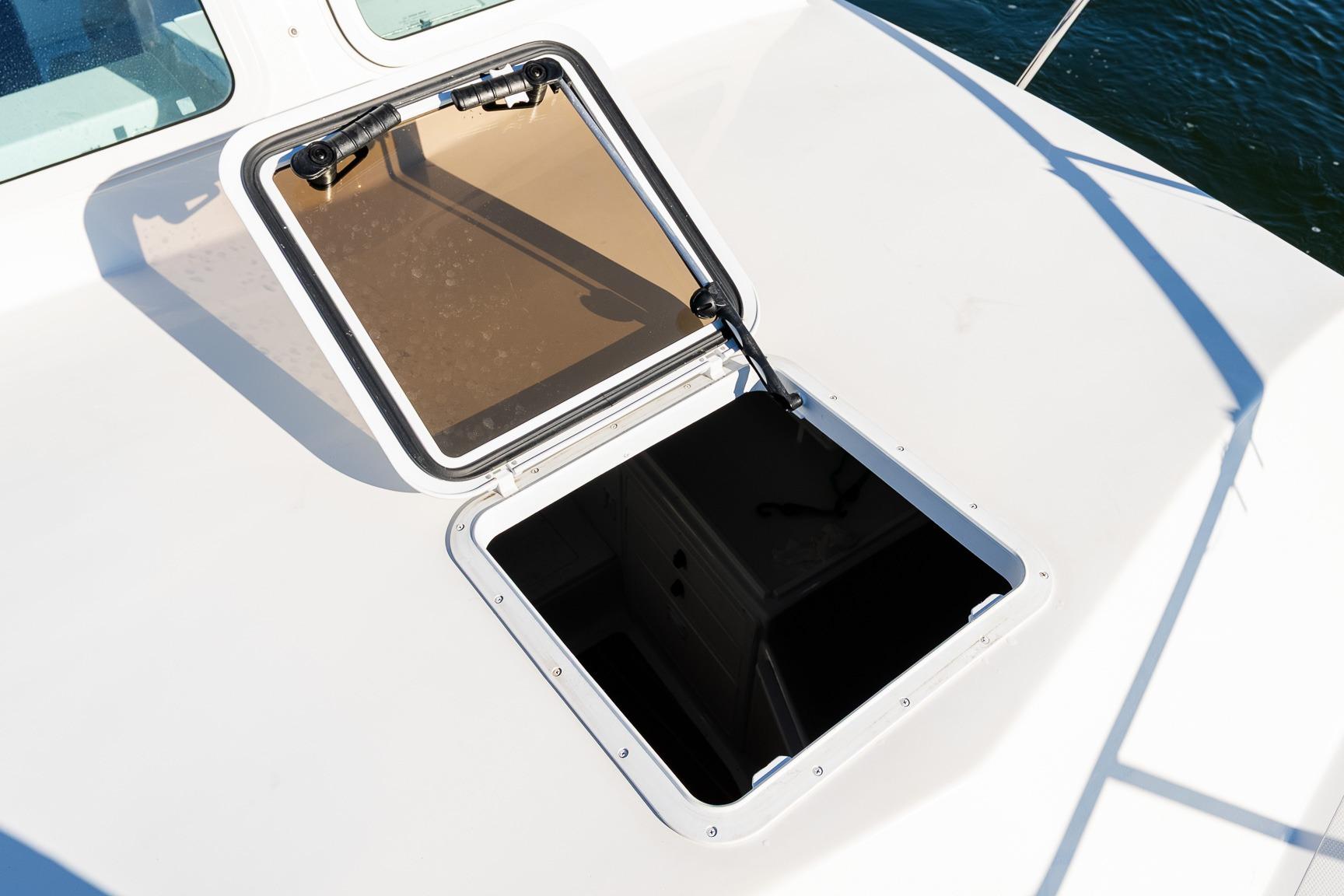 Open hatch on 2024 Steiger Craft 31 Fisherman boat deck, overlooking water.