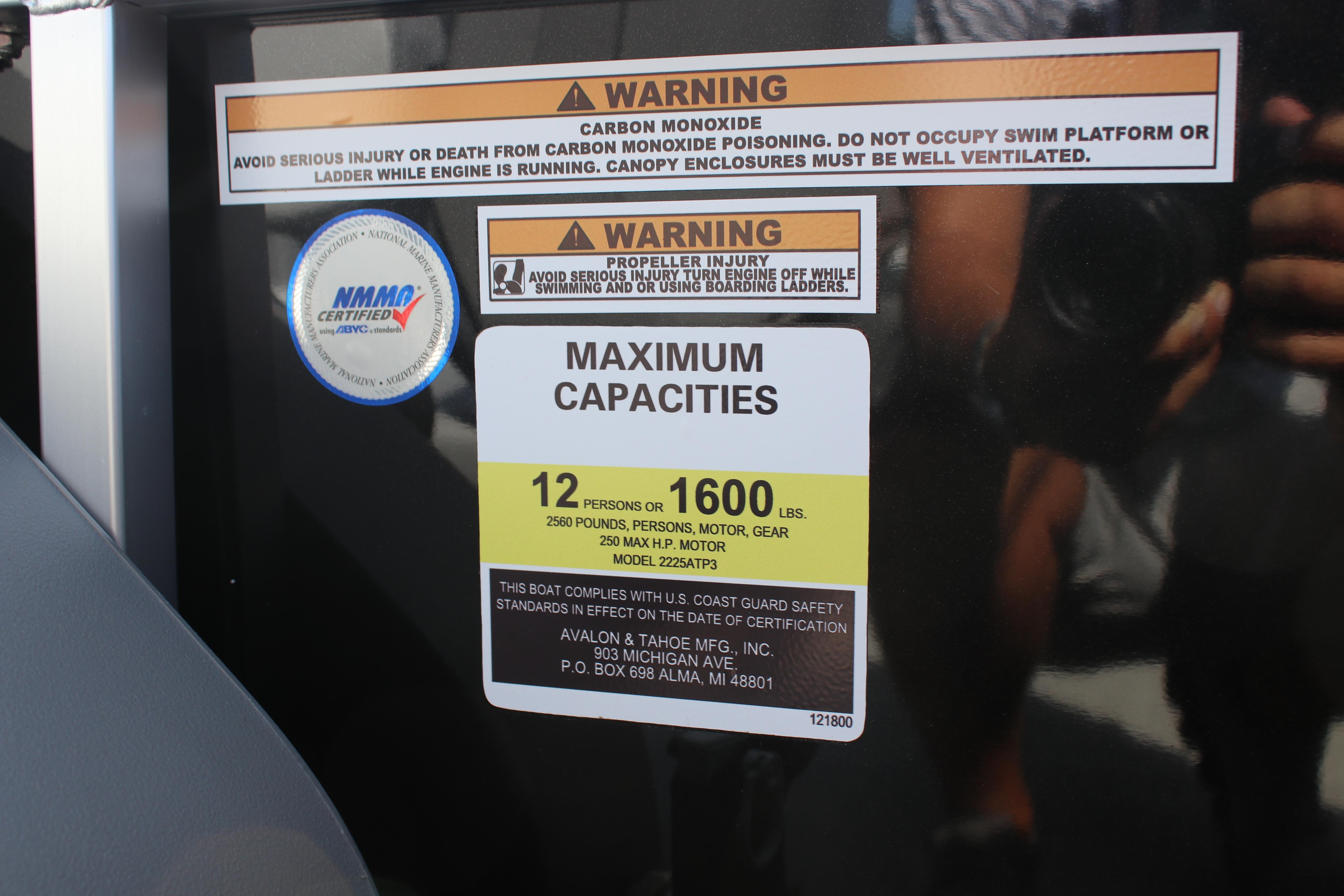Warning labels and capacity information on 2025 Avalon LSZ Quad Lounger boat.