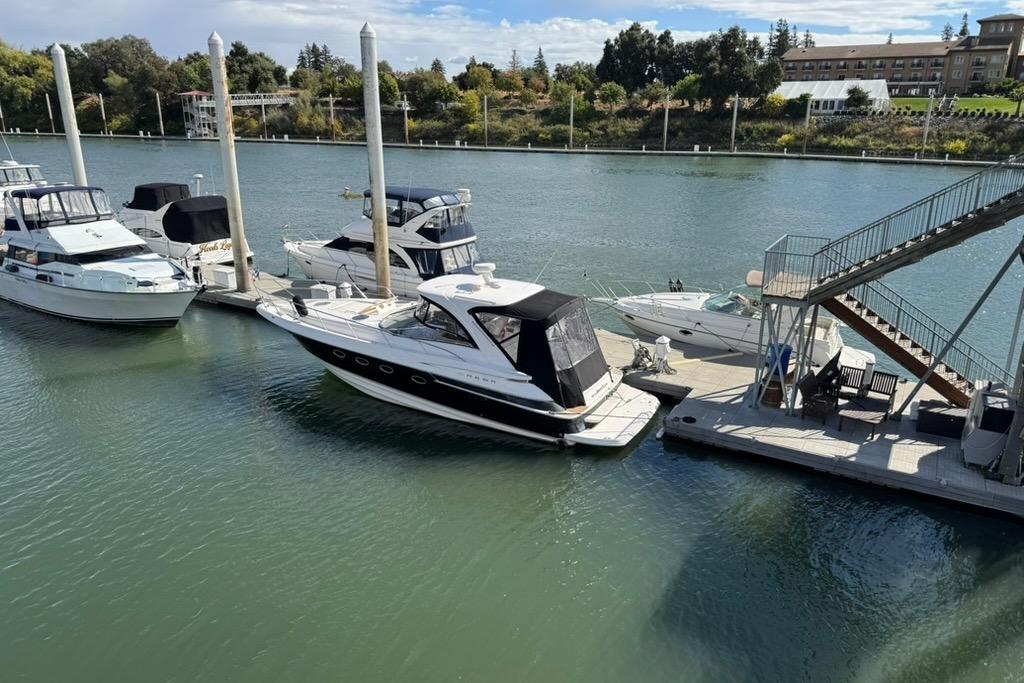 2006 Regal Commodore 4460 yacht docked at marina with other boats, scenic waterfront view.