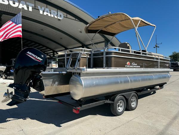 2025 Sun Tracker 24 Sportfish XP3 pontoon boat with Mercury engine at boat yard.