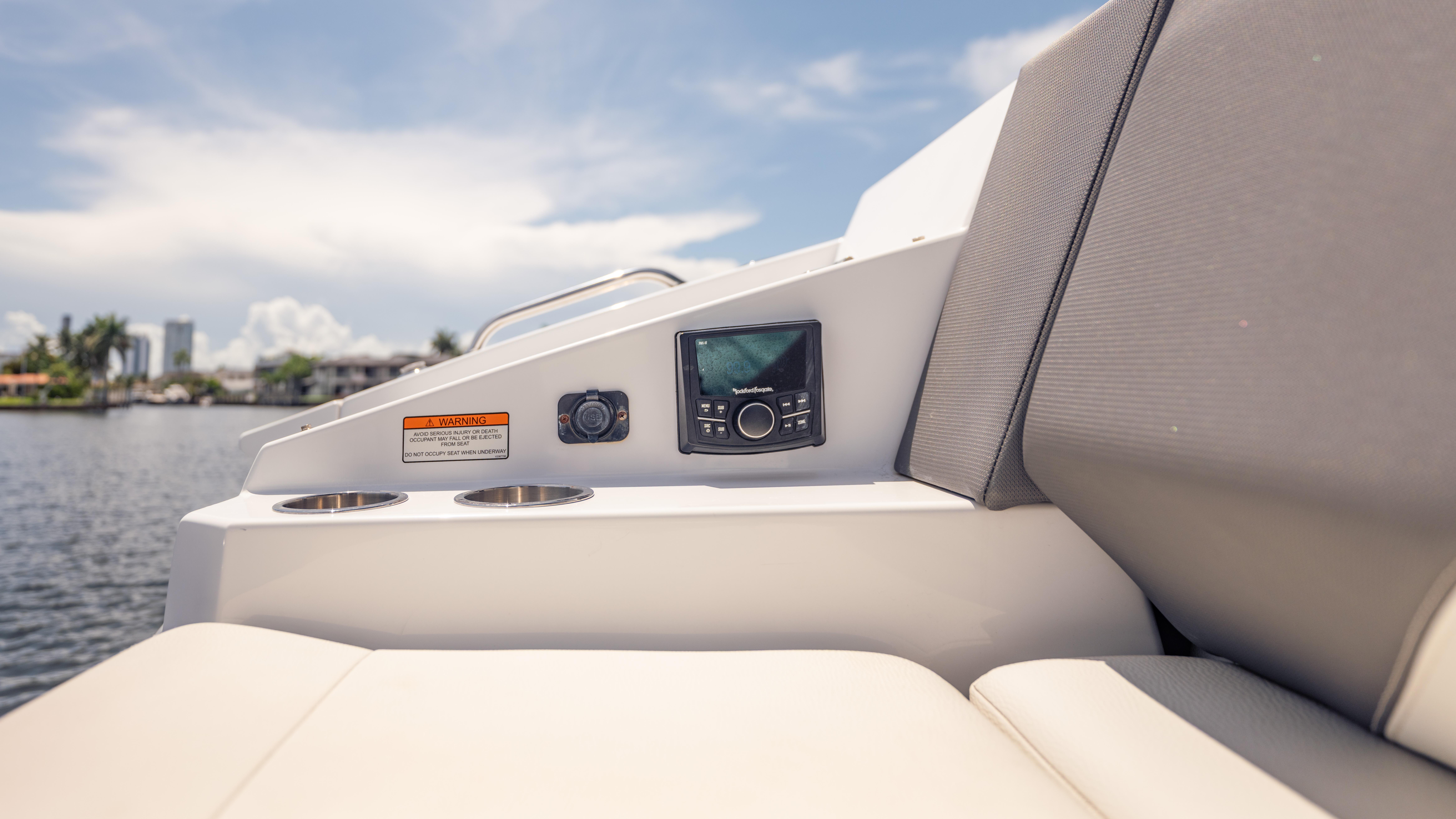 2021 Cruisers Yachts 38 GLS interior with control panel and cup holders, overlooking water.