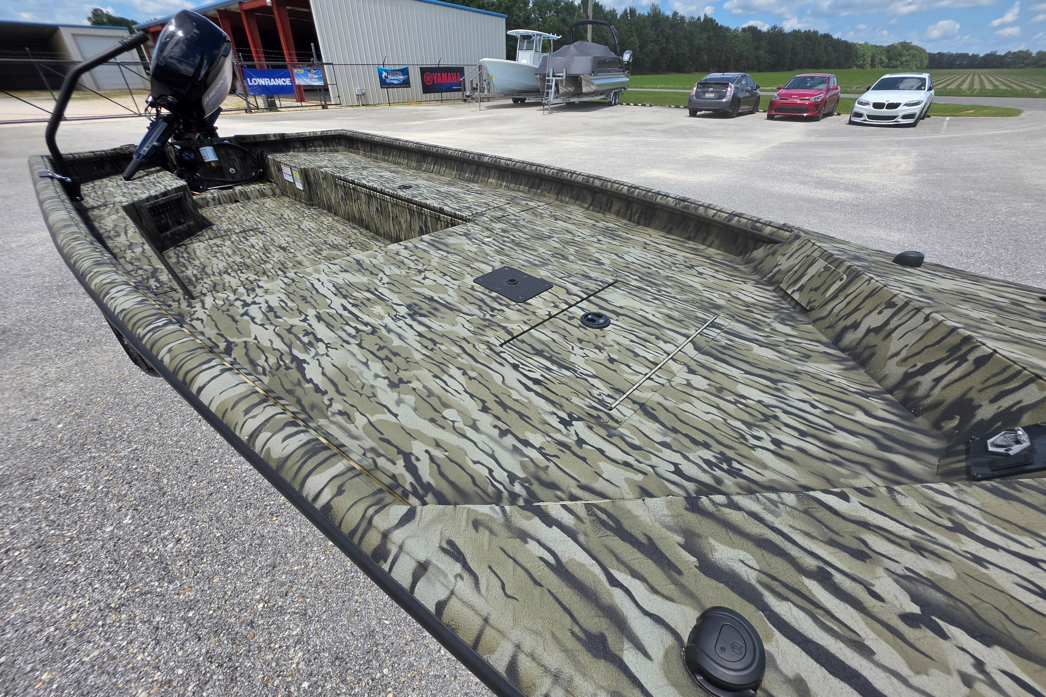 2025 SeaArk 1752 Slayer boat with camouflage design, parked outdoors.