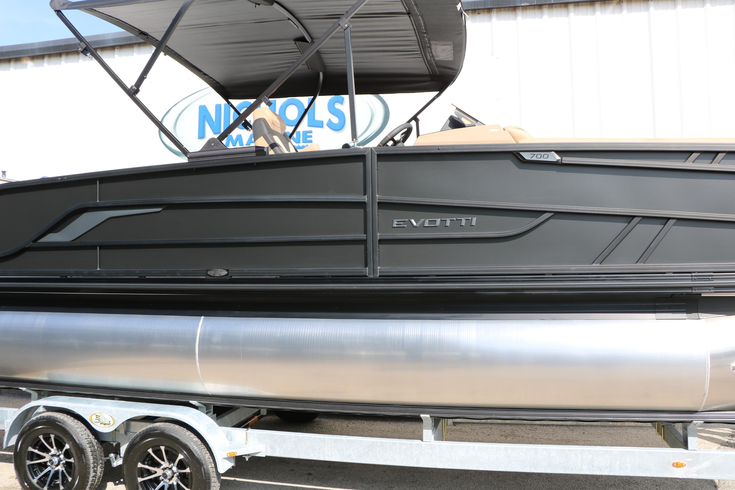 2026 Evotti 723CS pontoon boat on trailer, sleek black design, outdoor display.
