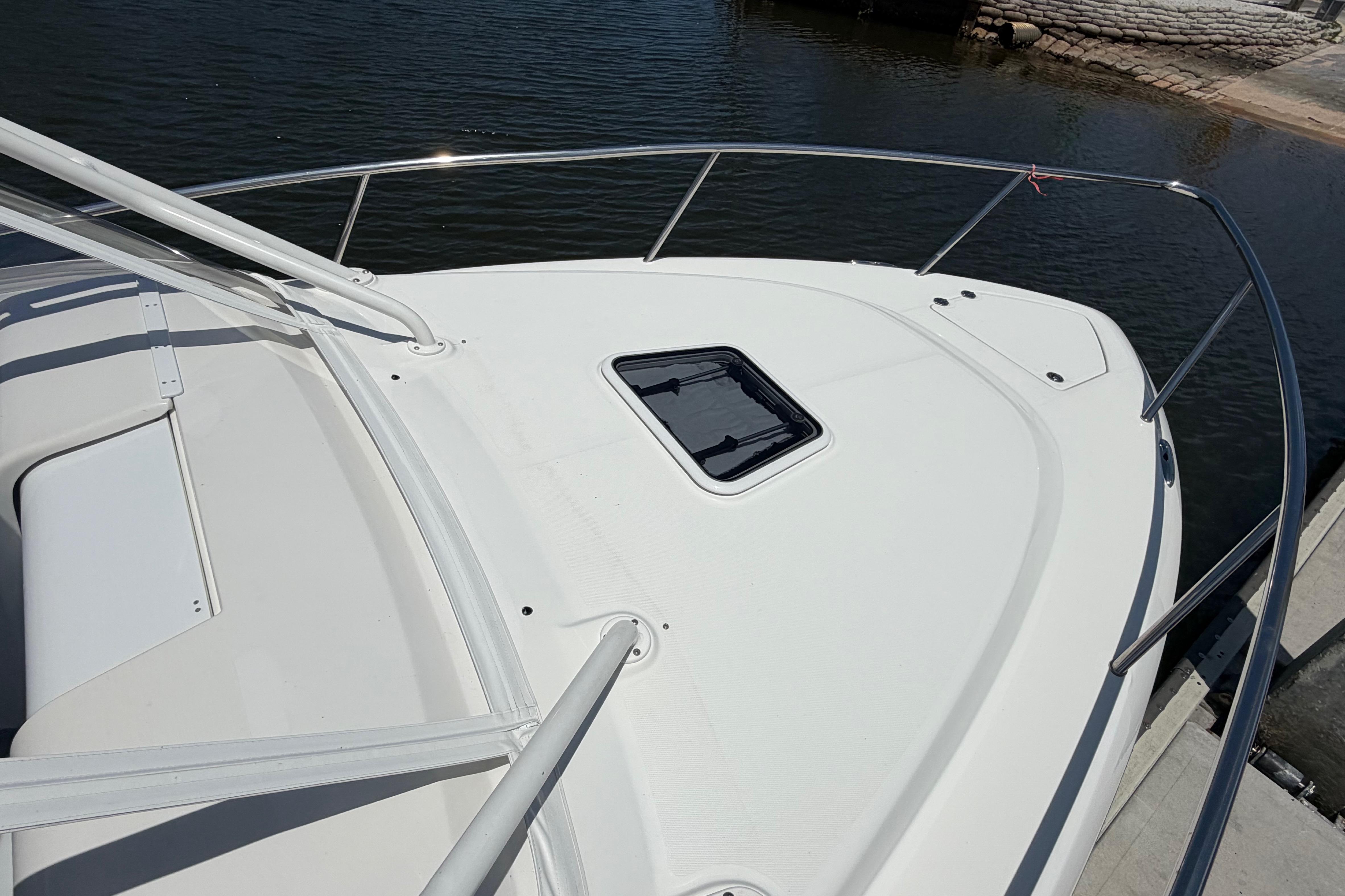 2009 Everglades 350LX boat deck with railing, docked by calm water.
