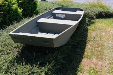 2026 Tracker Grizzly 14 Jon boat on grass, showcasing sturdy design and spacious interior.