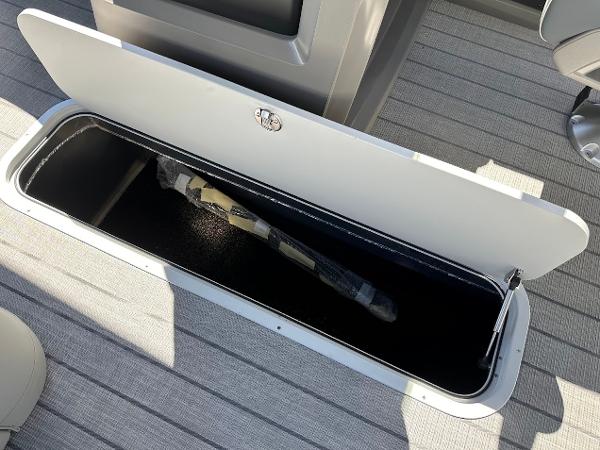 Storage compartment on 2025 Tahoe Pontoon 2585 LTZ Entertainer boat, open with item inside.