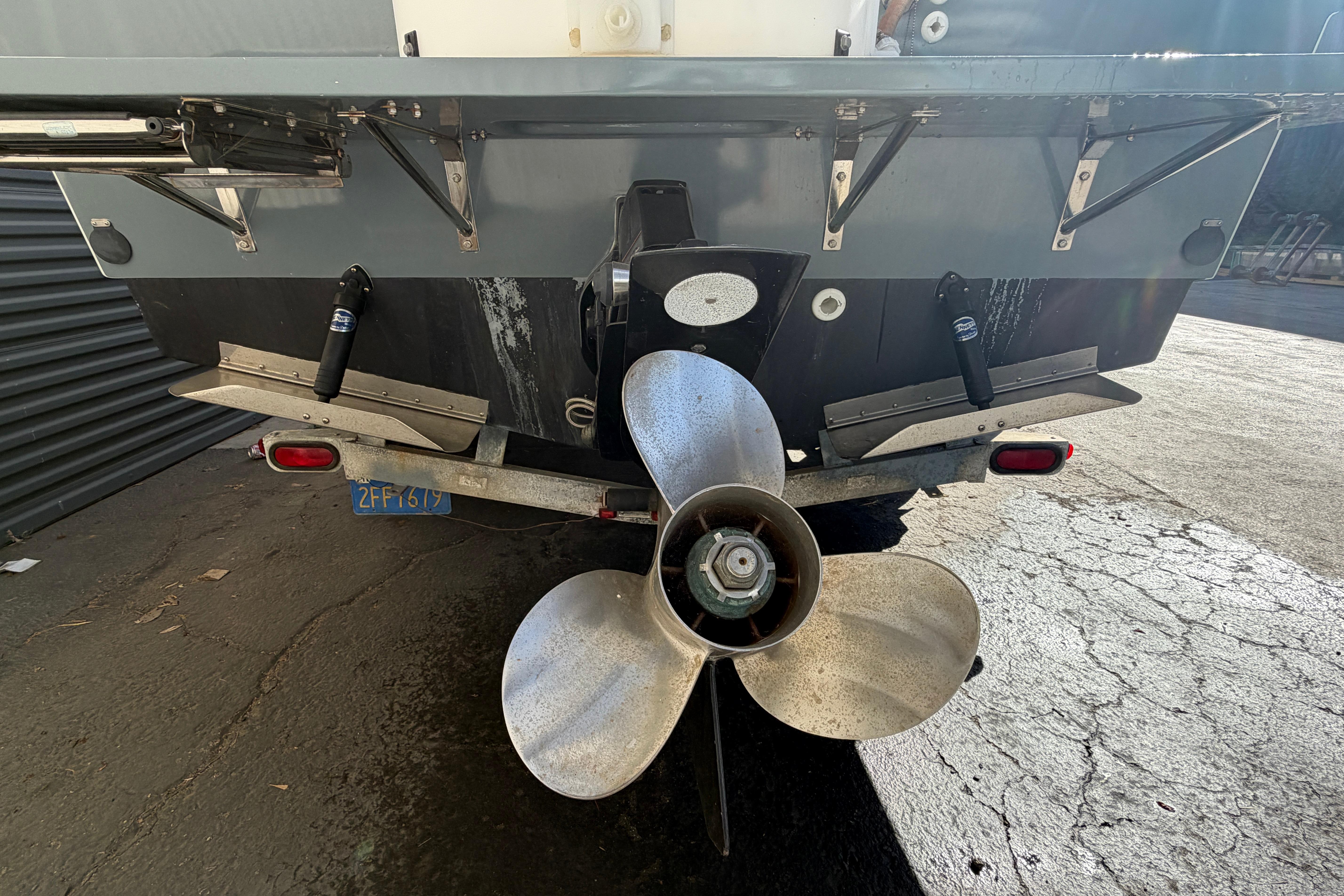 Rear view of 1986 Radon 21 Sport boat with large propeller and trailer.
