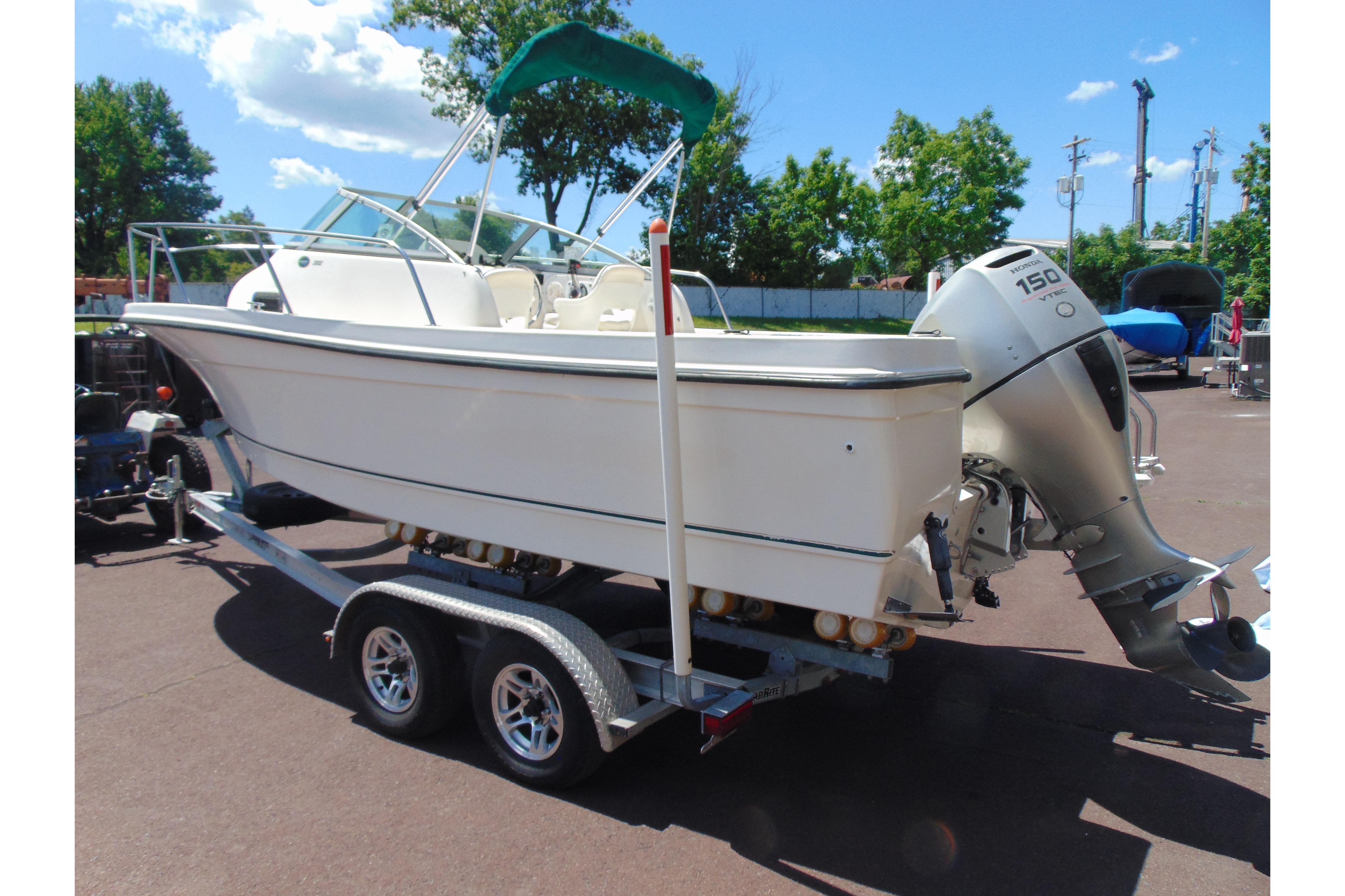 2002 Trophy Walkaround boat on trailer with outboard motor, parked outdoors.
