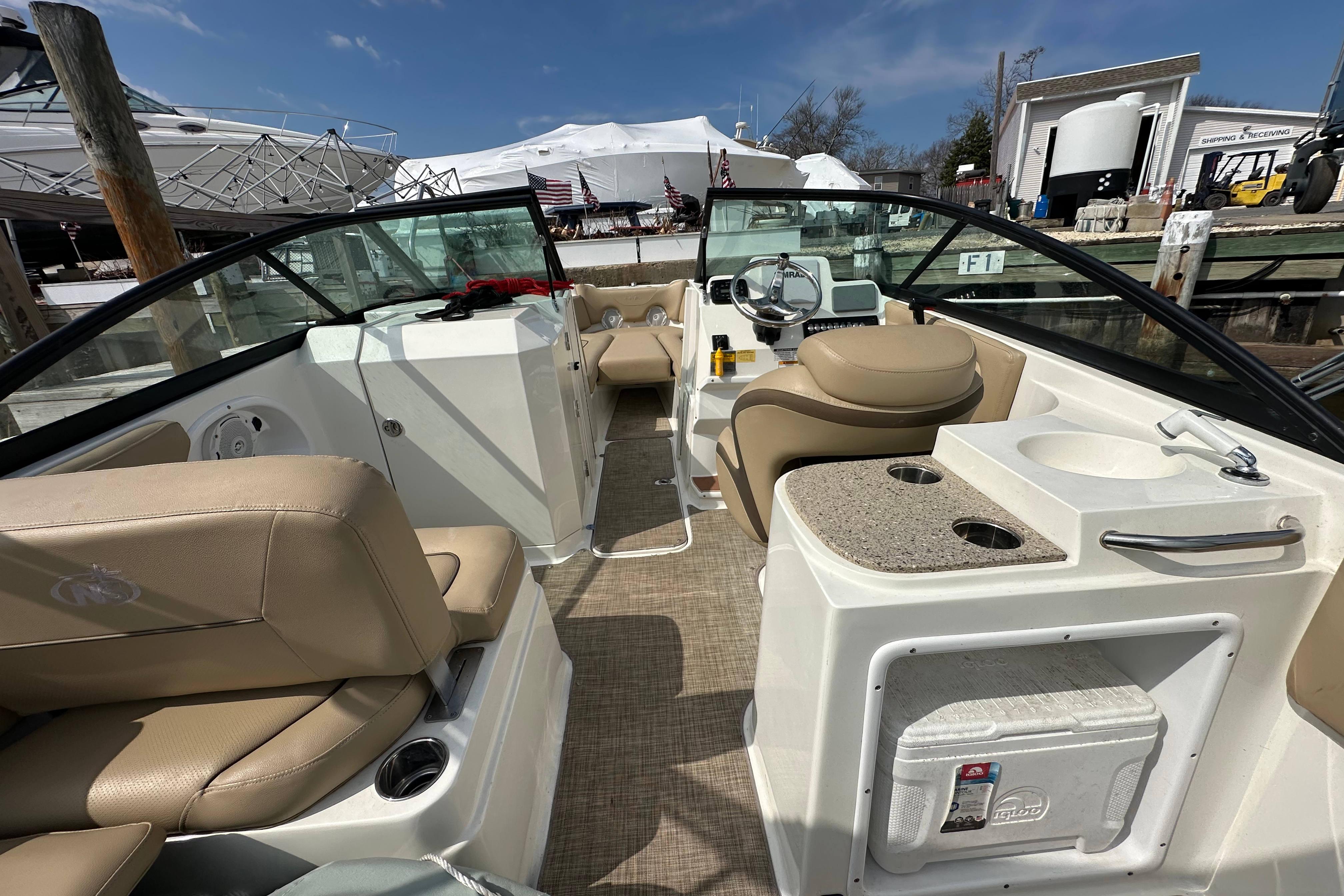 2018 NauticStar 2302 Legacy Dual Console boat interior with beige seating and helm.