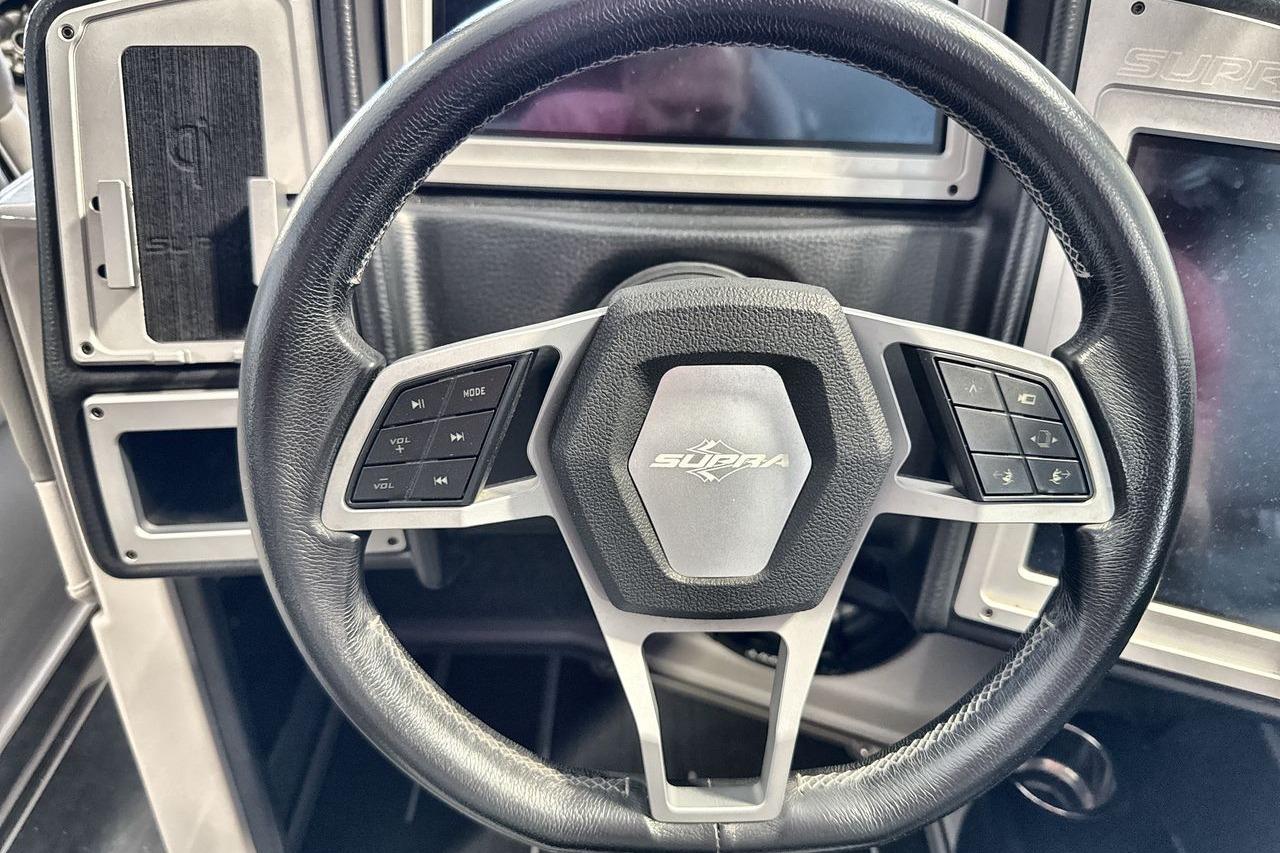 Steering wheel of a 2021 Supra SE 550 with integrated controls and modern design.