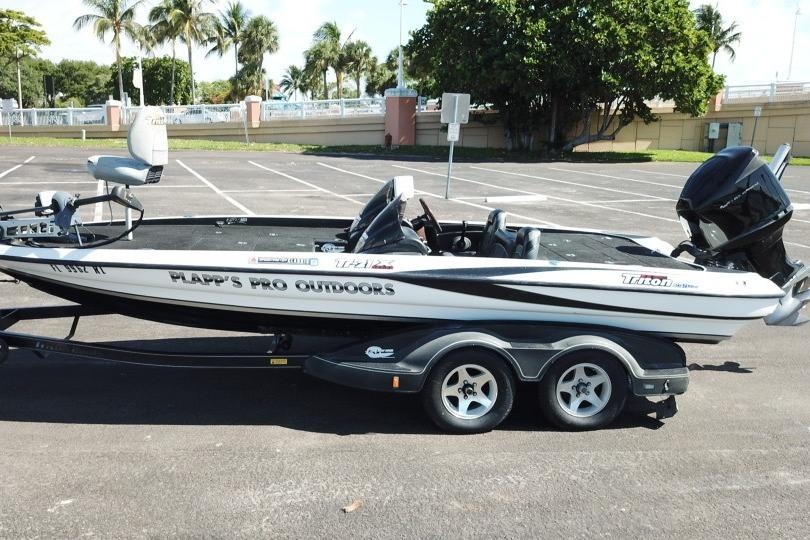 2005 Triton Tr-21X PD boat on trailer in parking lot, palm trees in background.