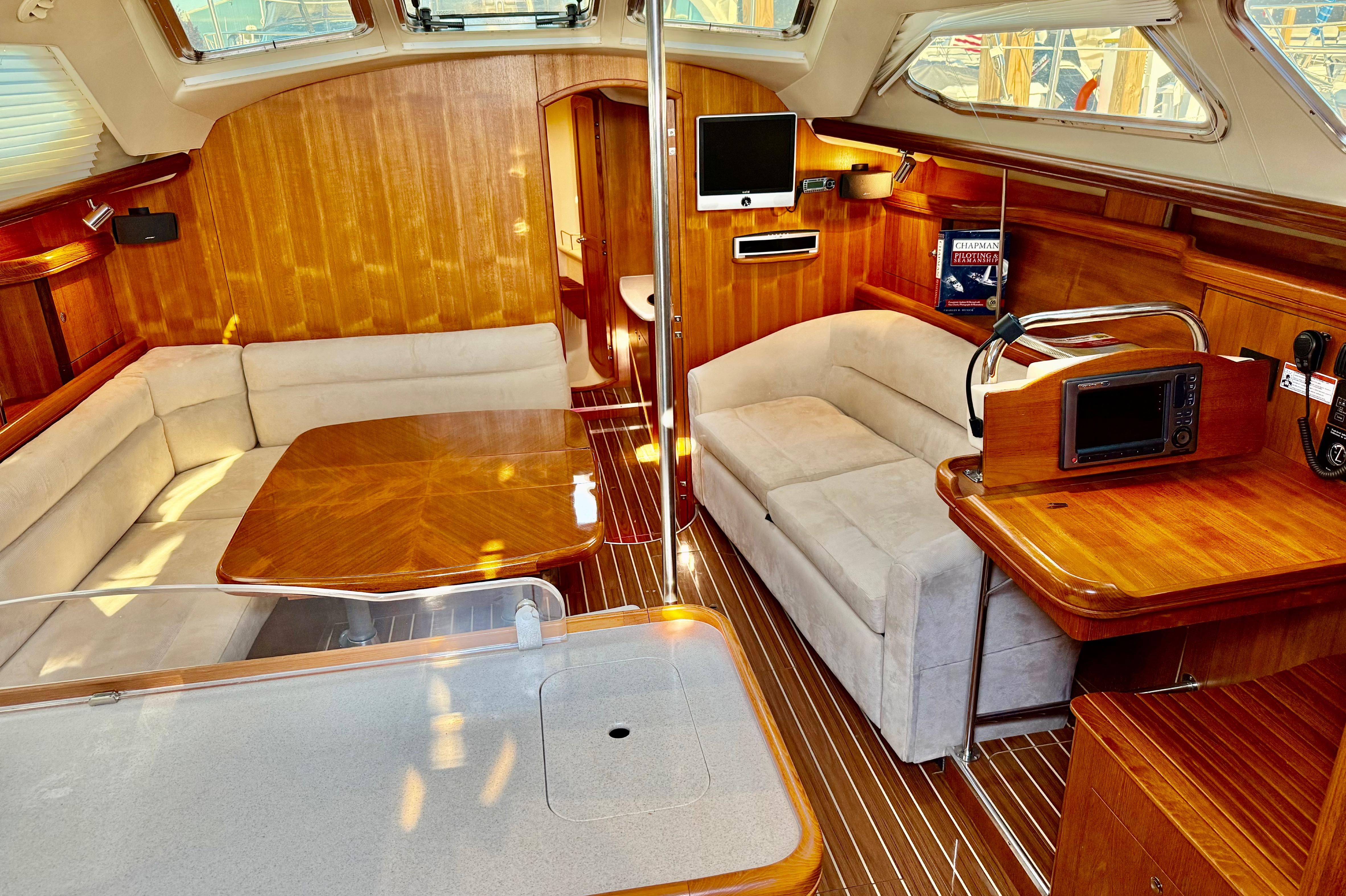 Luxurious interior of 2007 Hunter 41 Deck Salon with wood finish and plush seating.