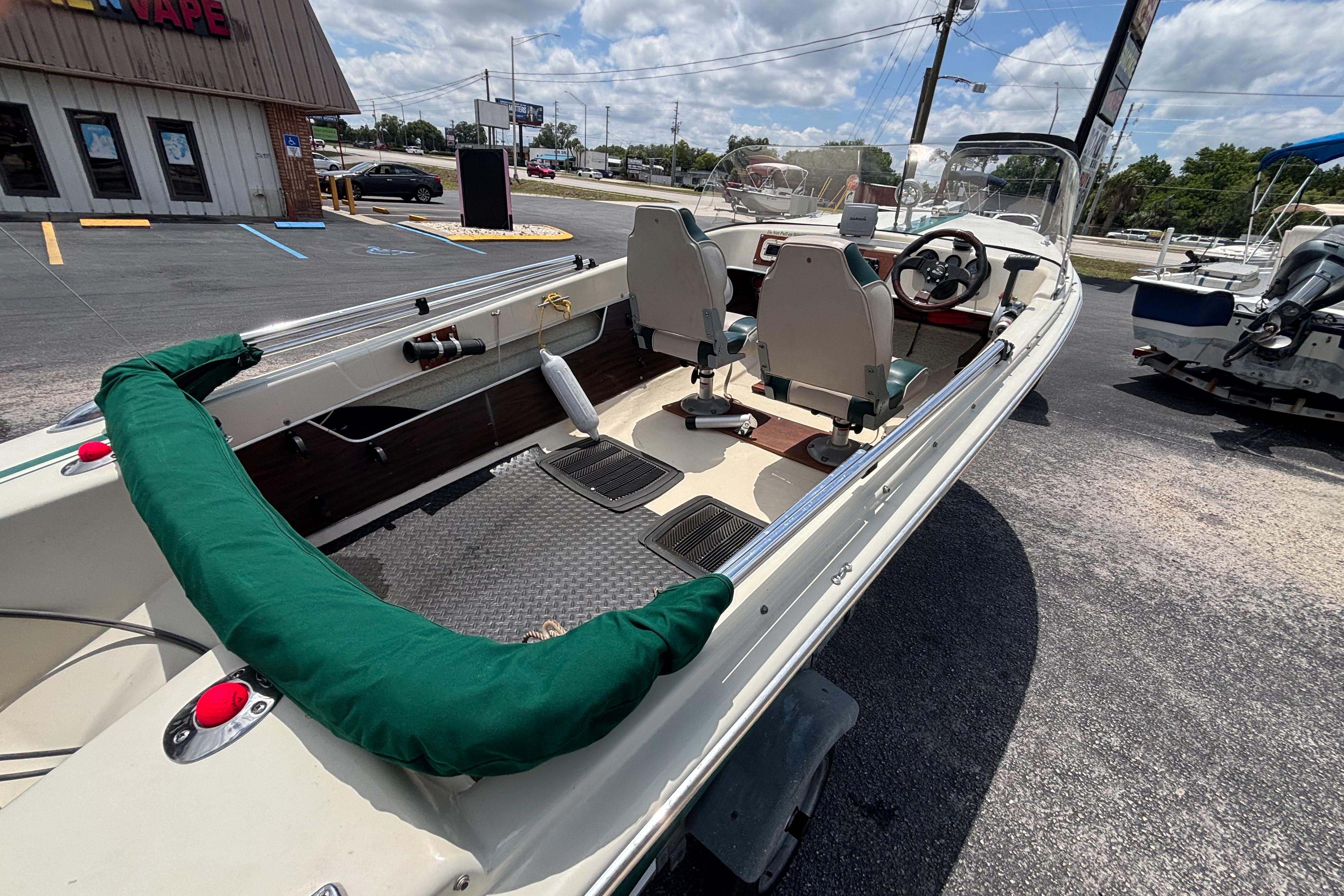 1966 Mohawk 15 boat with green trim, parked outdoors under a cloudy sky.