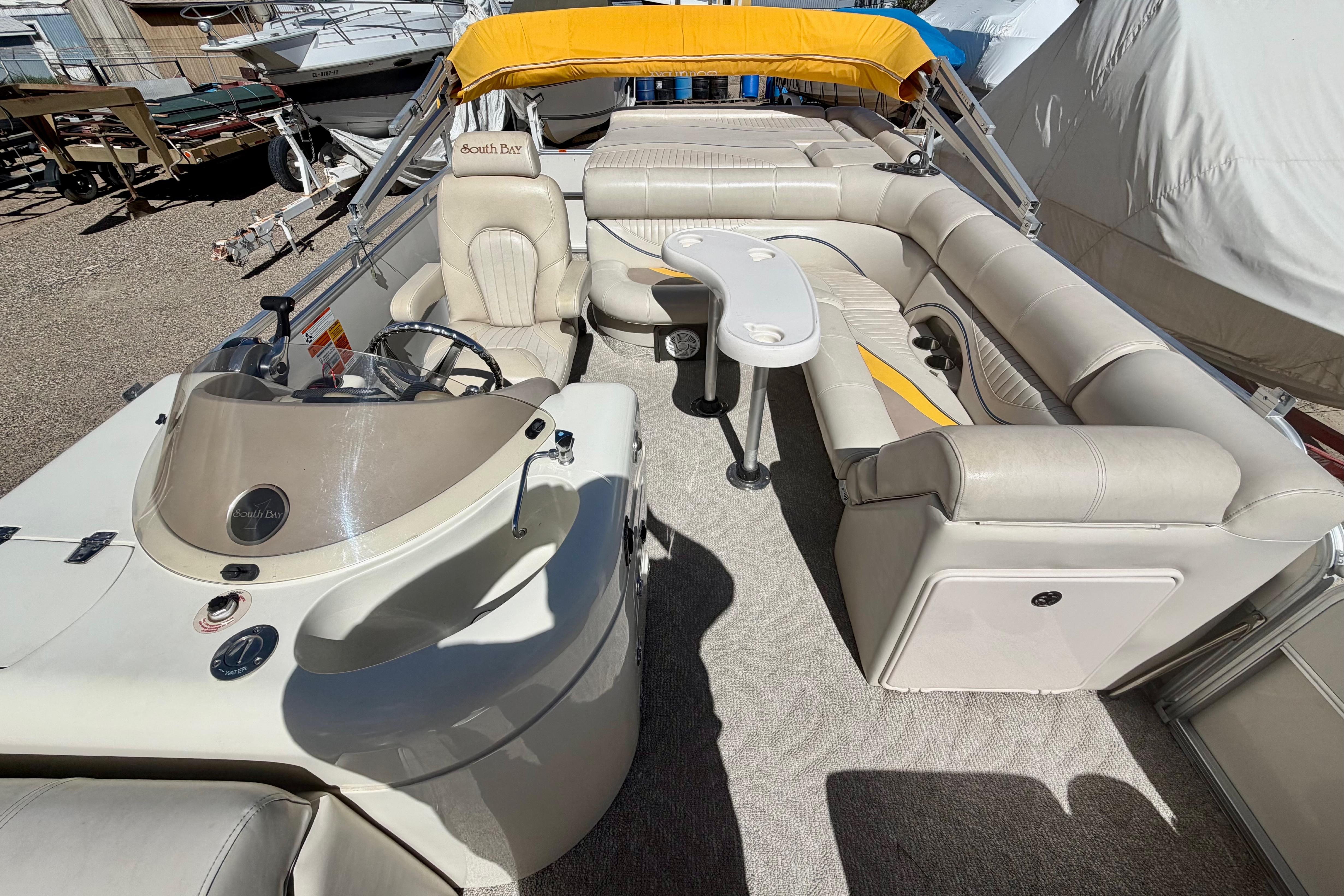 2006 South Bay 925CR pontoon boat interior with beige seating and yellow canopy.