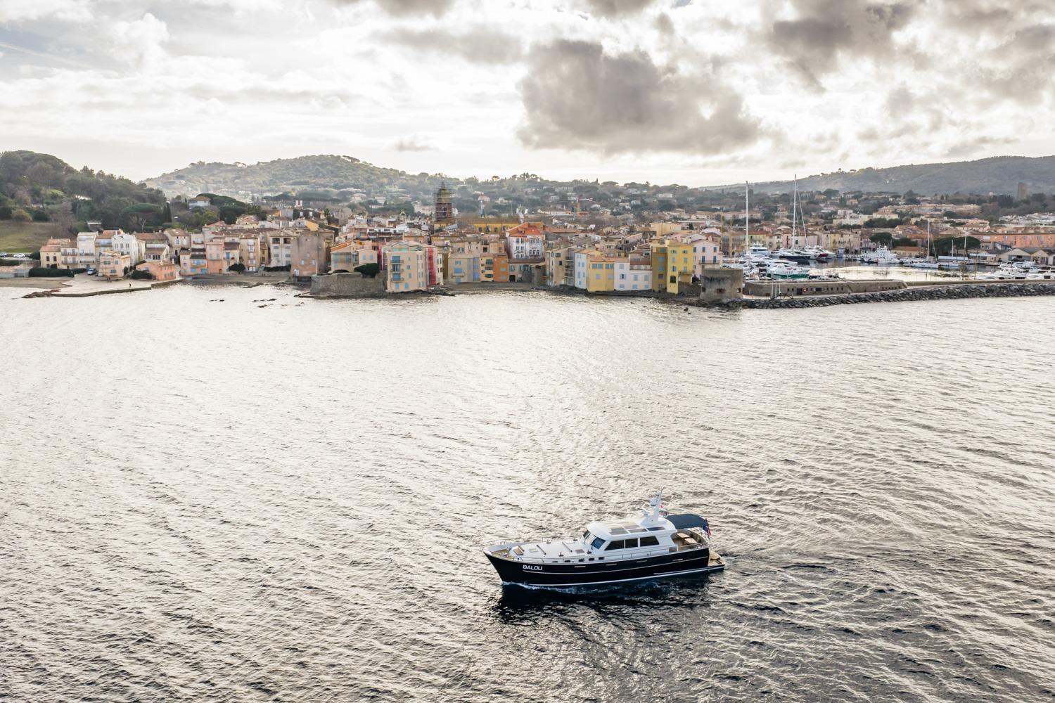 Sturier 620 OC yacht cruising near a picturesque coastal town, 2013 model.