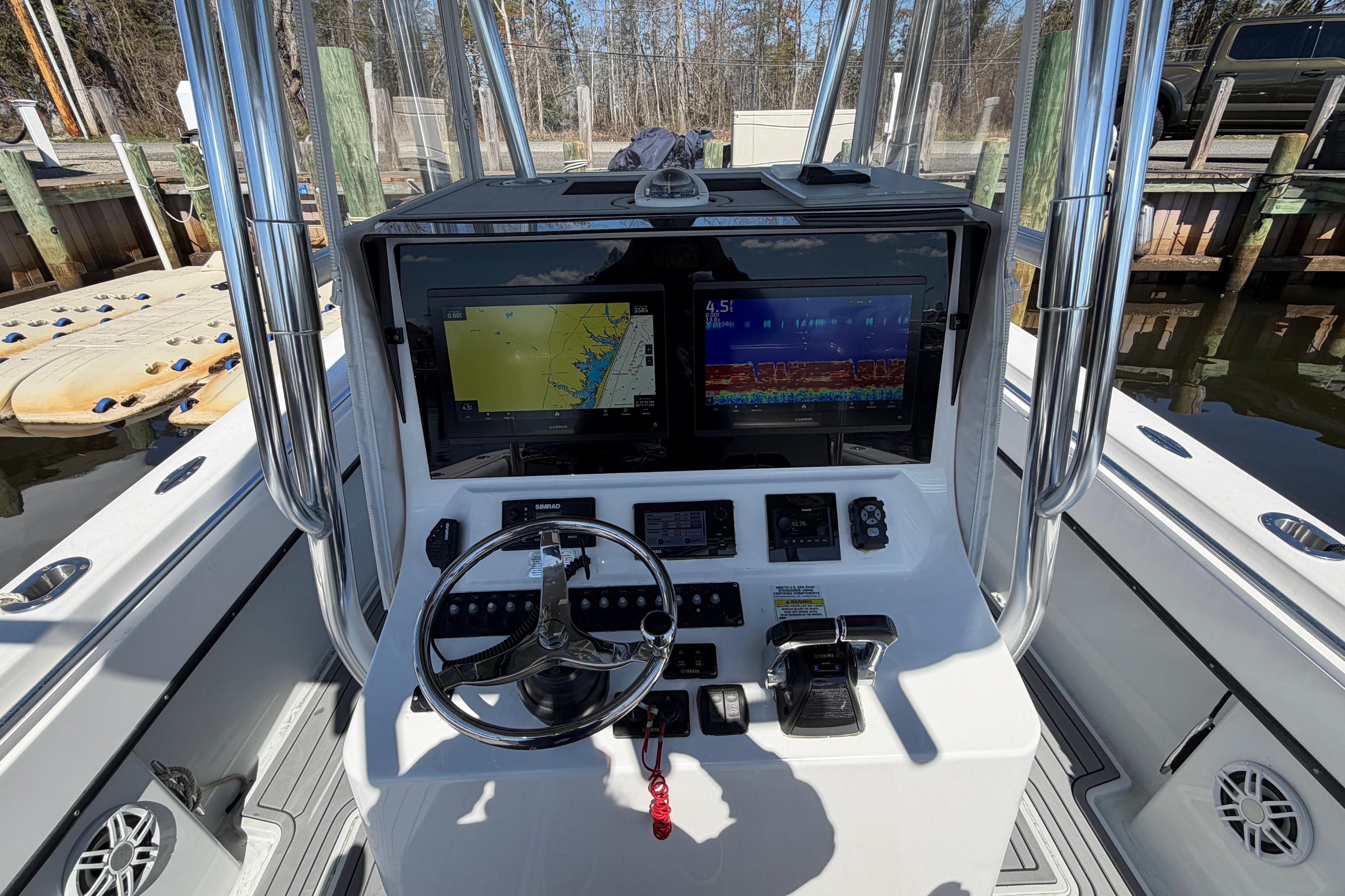 2015 Contender 32 ST boat dashboard with navigation screens and steering wheel.