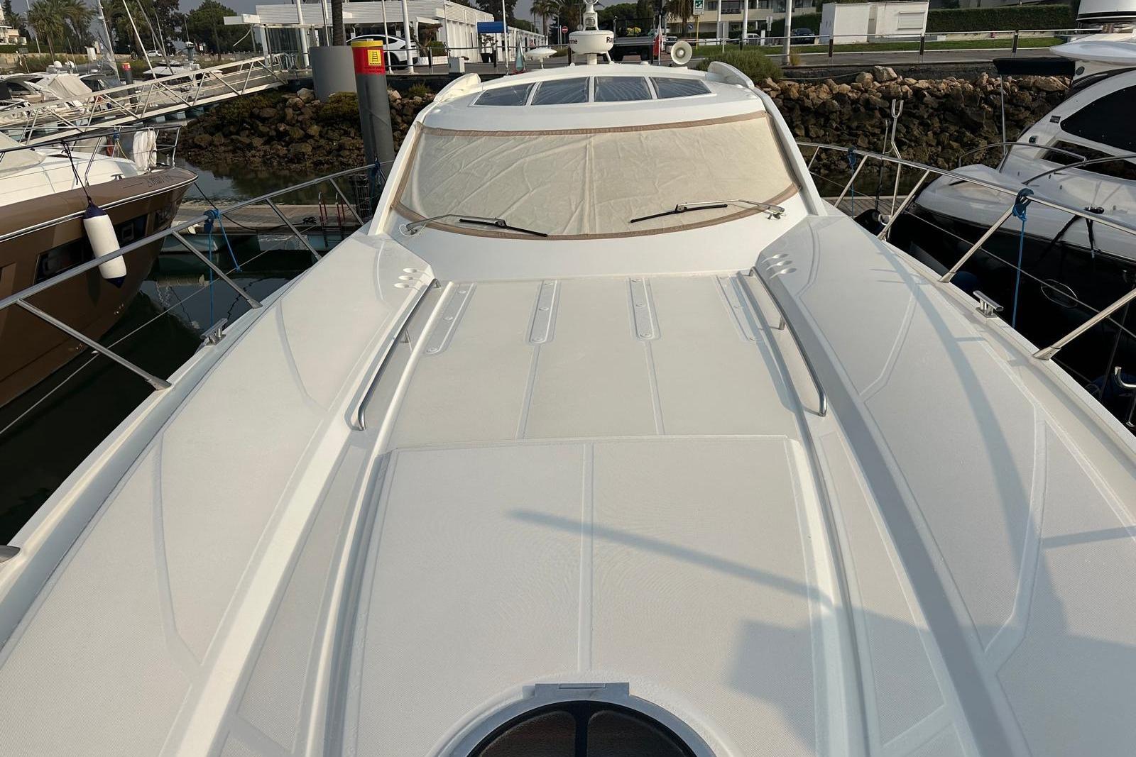 Luxury Absolute 56 yacht from 2007 docked at marina, showcasing sleek design.