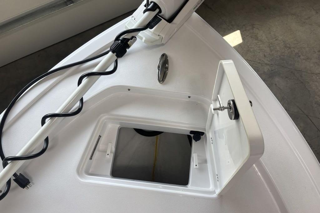 2026 Sportsman Masters 247 Bay Boat bow with open storage compartment and trolling motor.