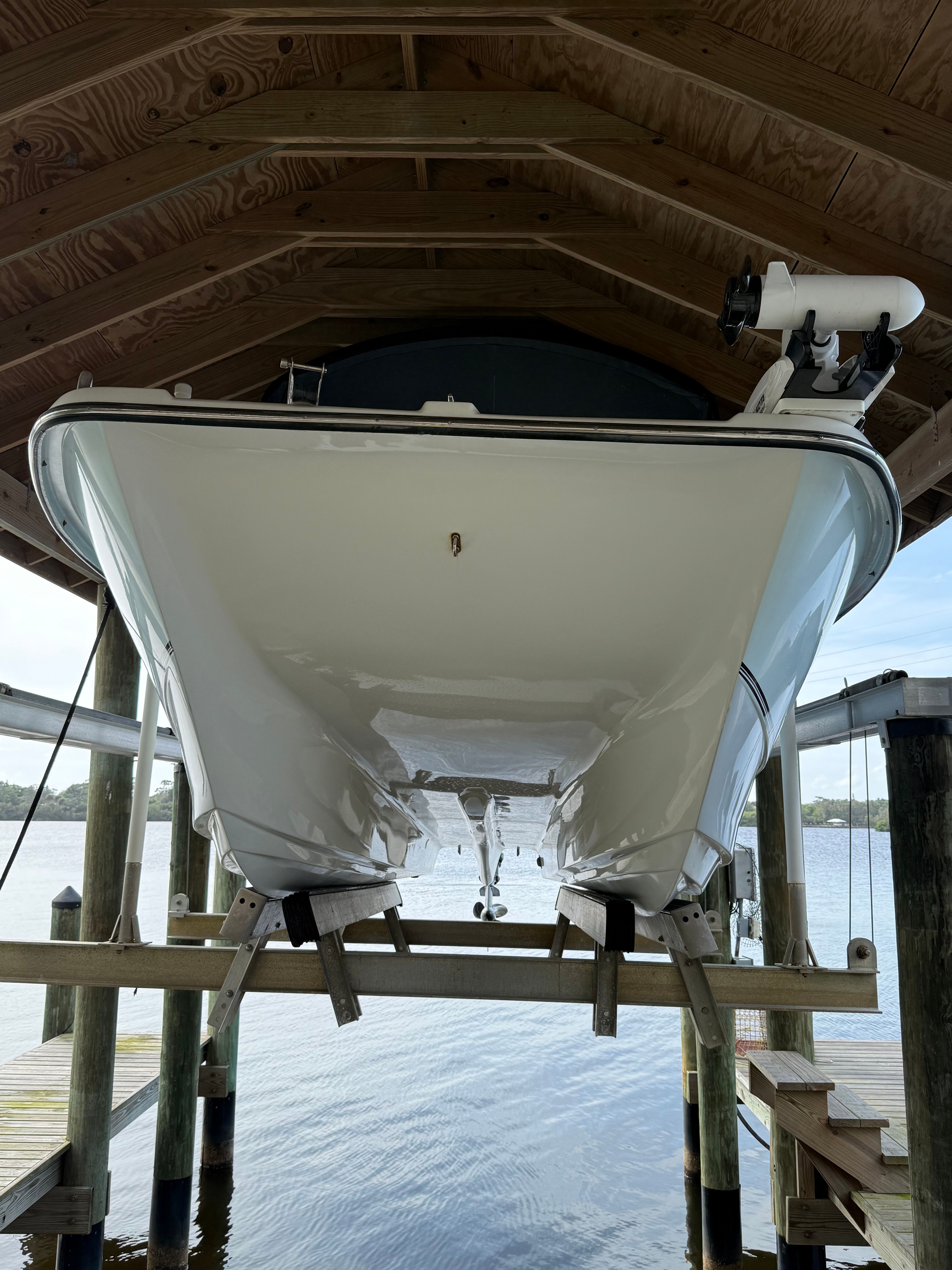A 2011 Carolina Cat 18CC boat is on a boat lift above the water.