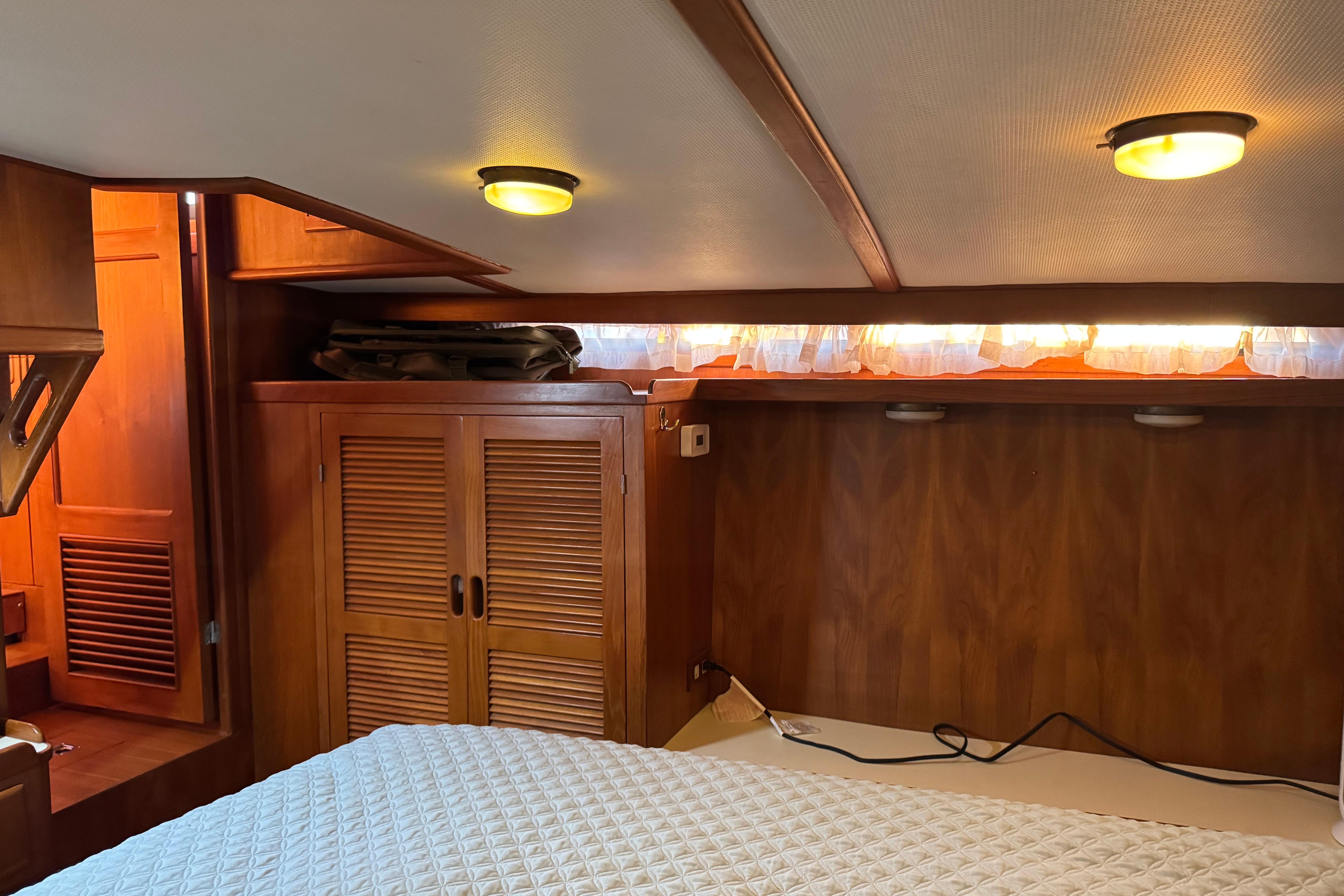 Cozy cabin interior of 1987 President 37 yacht with wooden furnishings and soft lighting.