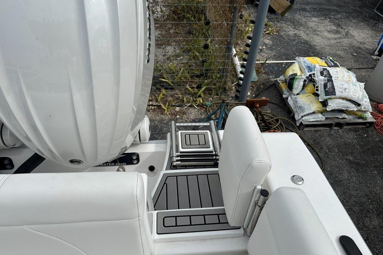 2026 Tidewater 272 LXF boat deck with seating and engine, outdoor setting.