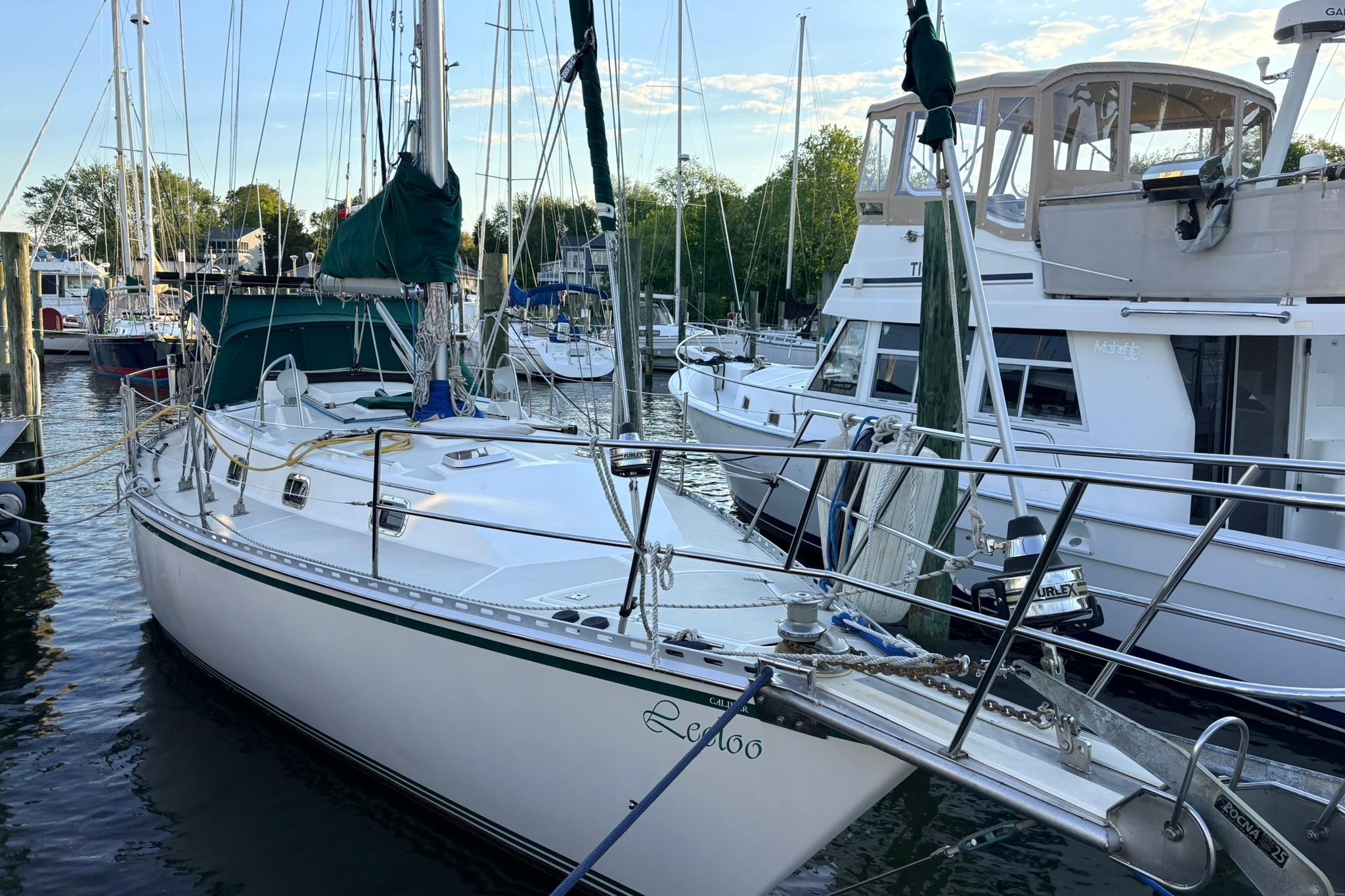 2009 Caliber 40LRC SE sailboat docked at a marina, surrounded by other boats.