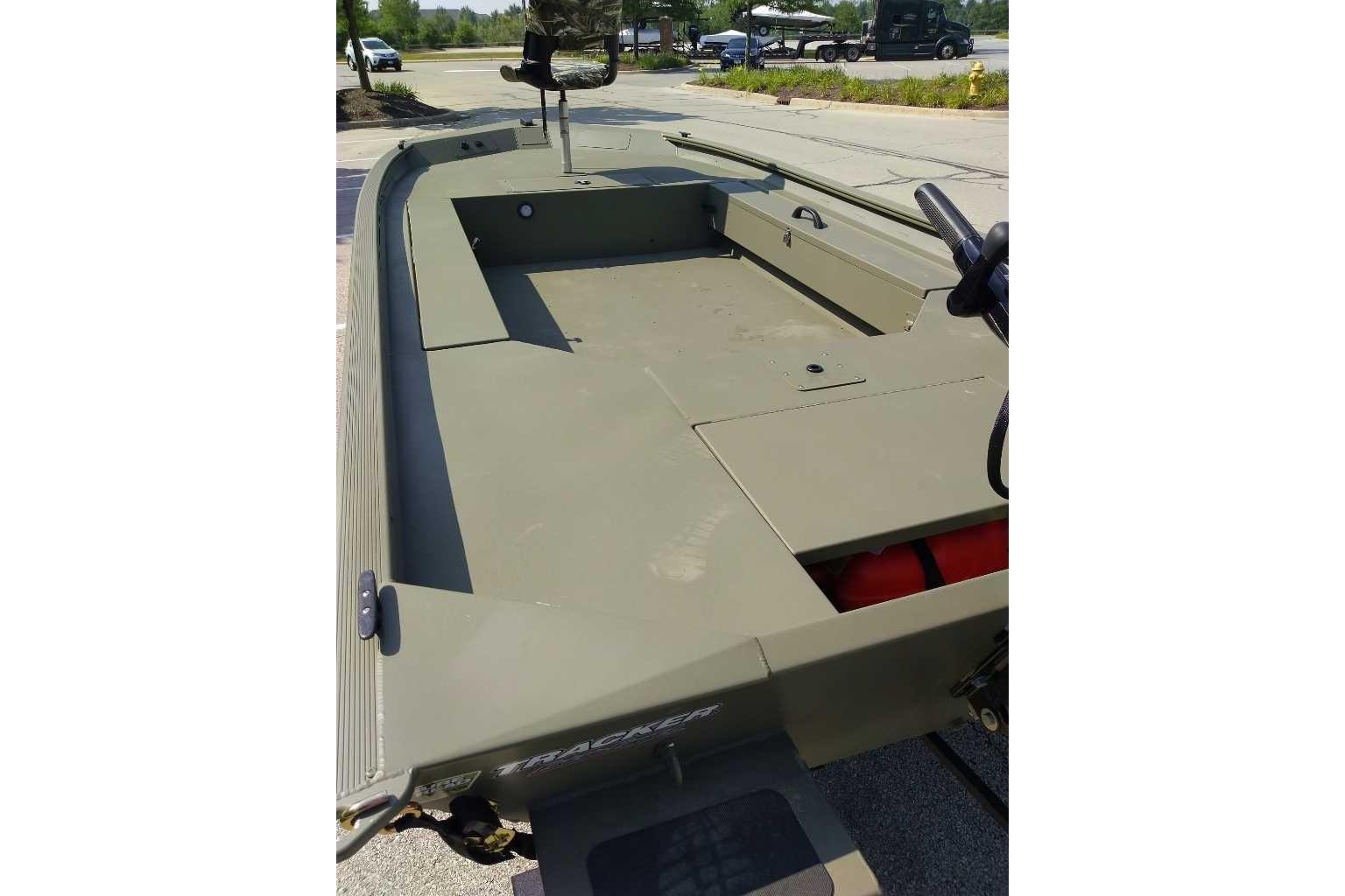 2026 Tracker Grizzly 1654 T Sportsman boat, olive green, parked outdoors.