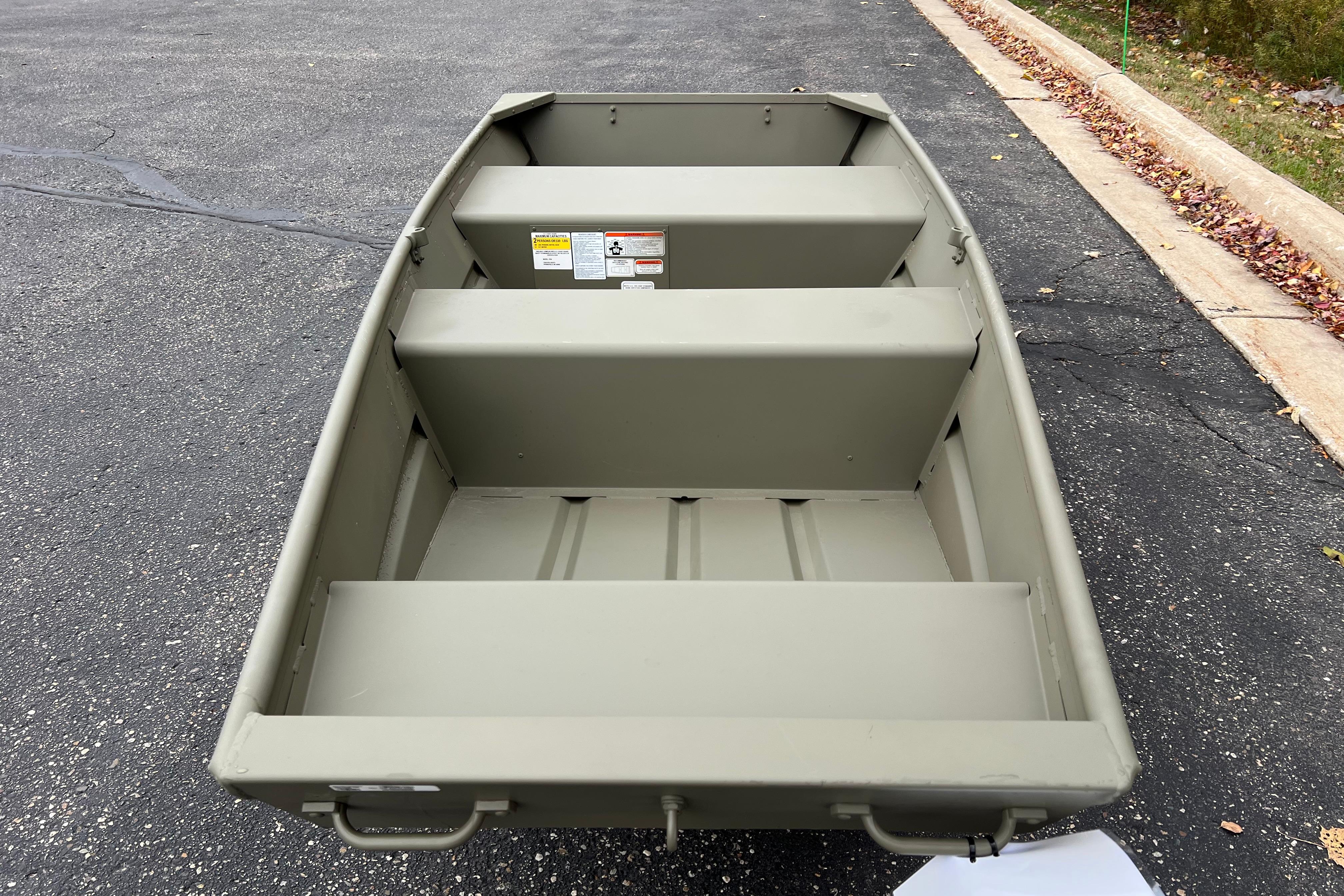 2026 Tracker Grizzly 10 Jon boat on pavement, showcasing interior seating and design.