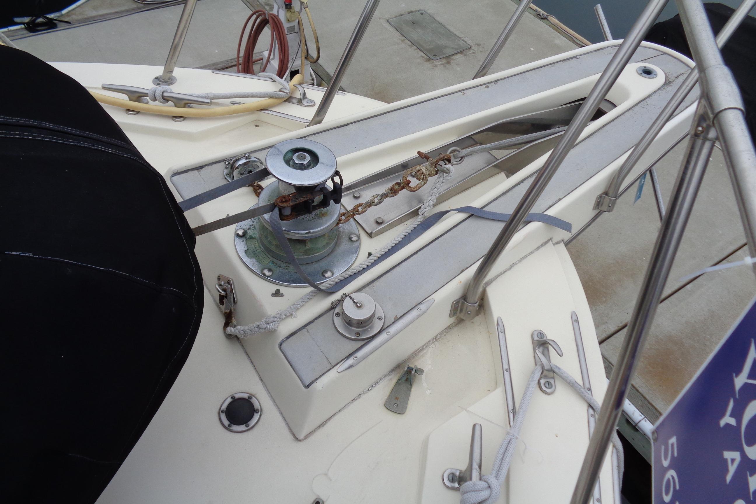 Anchor winch on 1981 Hatteras 48 Cockpit Motor Yacht deck, featuring ropes and railing.