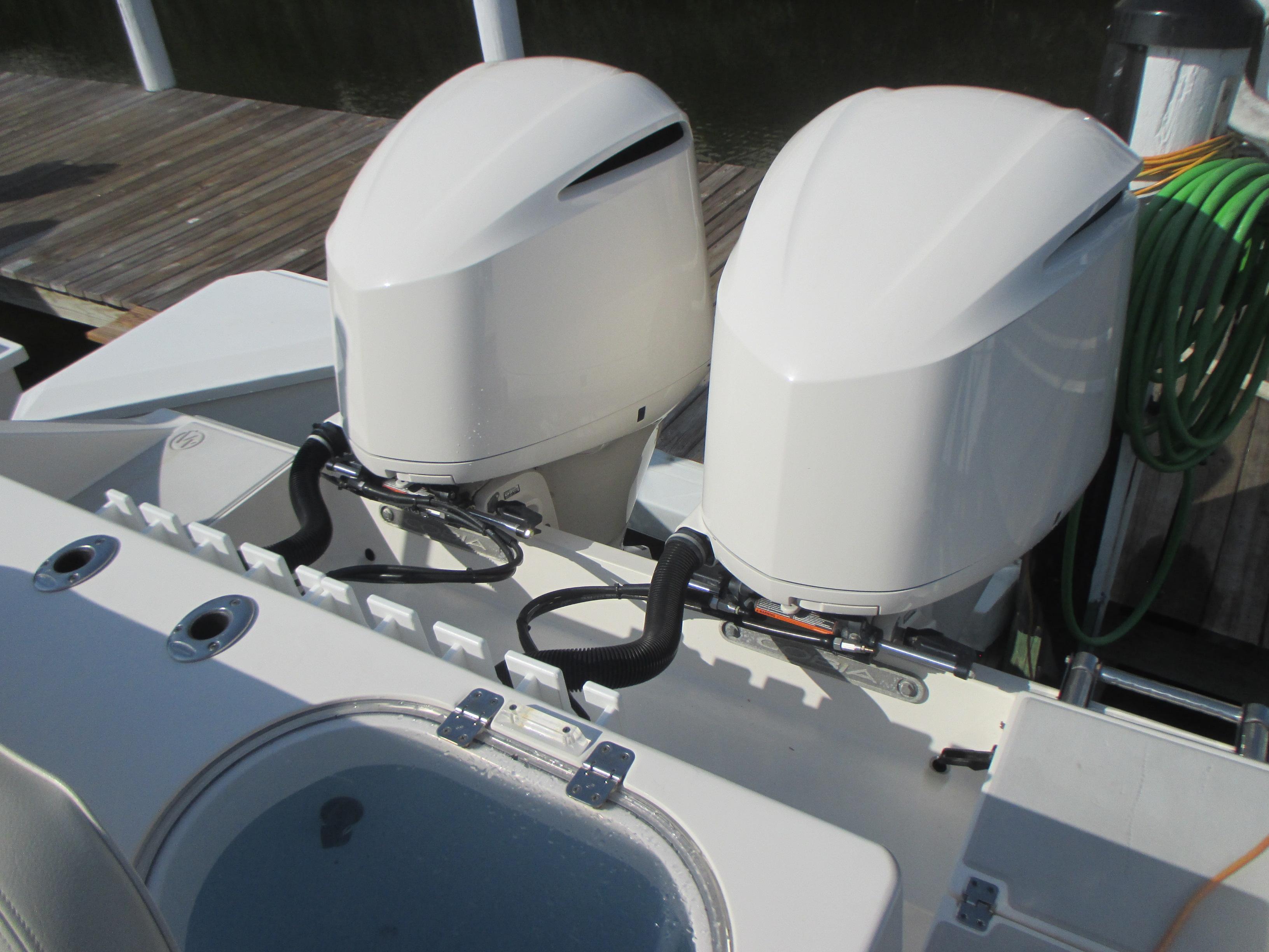 2018 Cobia 301 Center Console with dual outboard engines at dock.