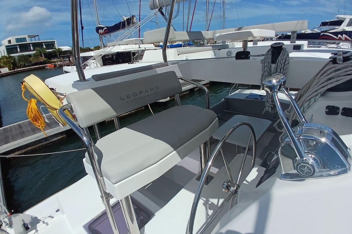 2022 Leopard 42 catamaran helm station with steering wheel and seating at marina.