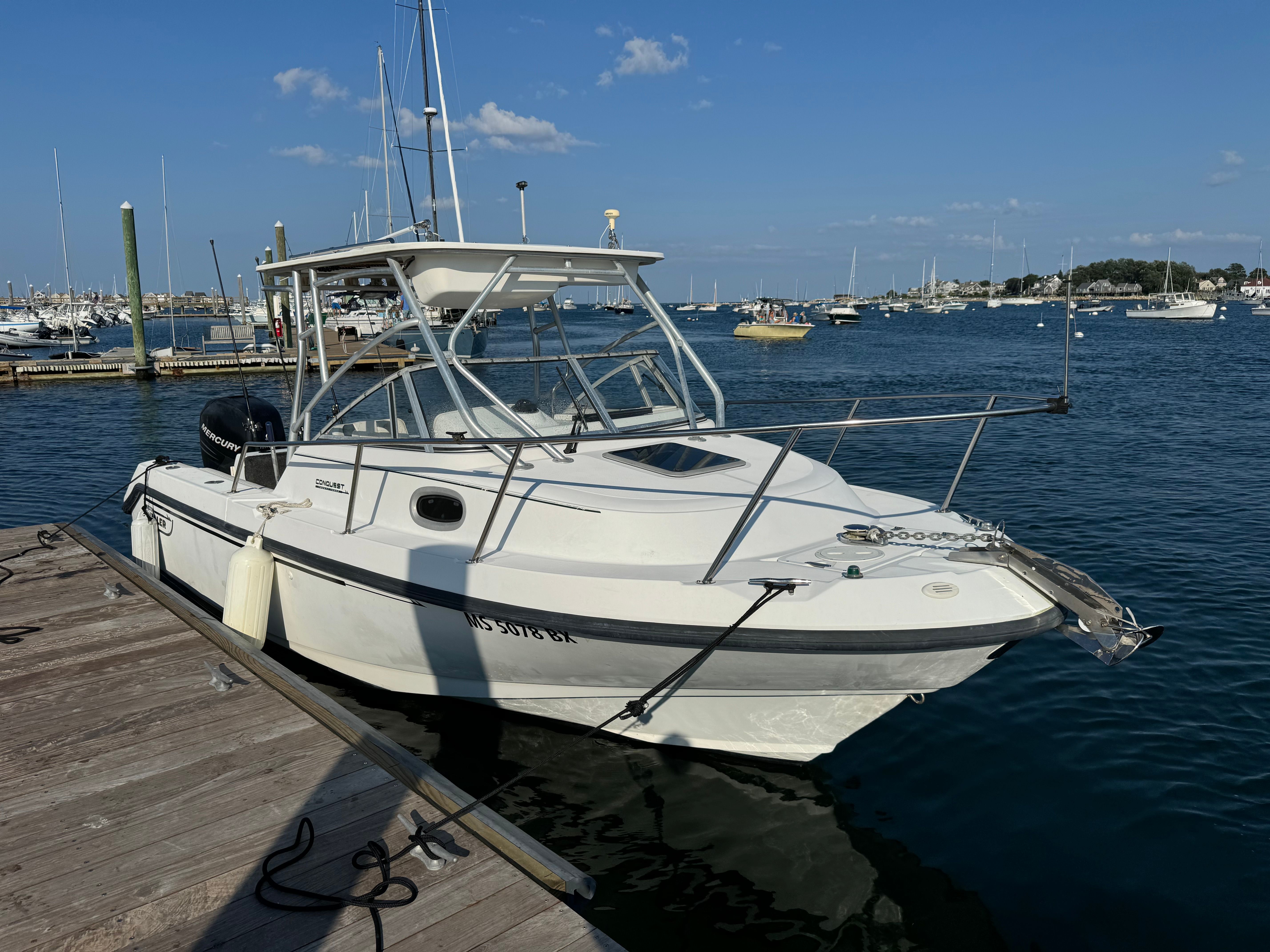 Boston Whaler Conquest 2000 at dock, calm water, blue sky.