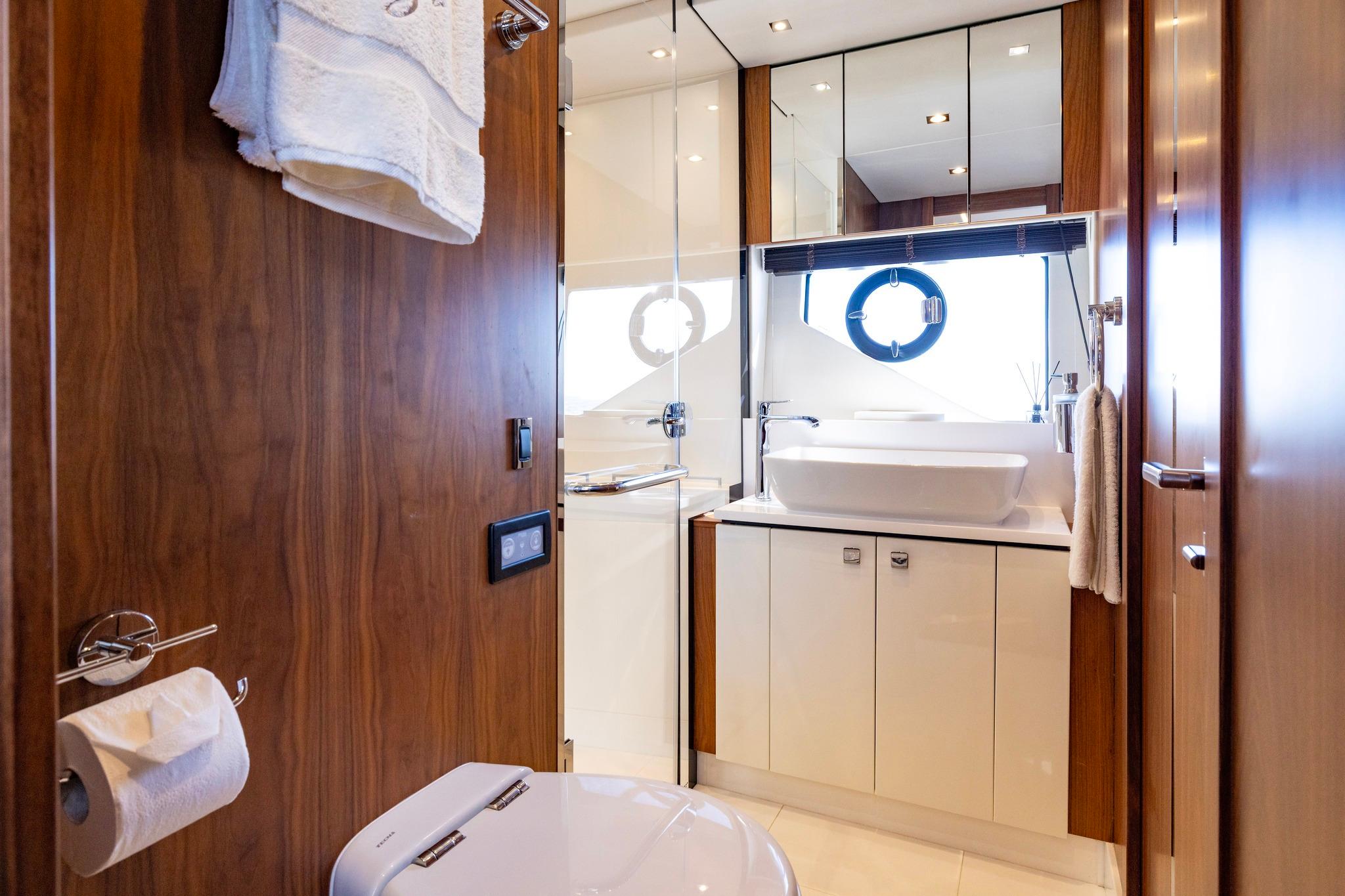 Luxurious bathroom interior on 2020 Sunseeker Predator 74 yacht, featuring modern fixtures and wood accents.