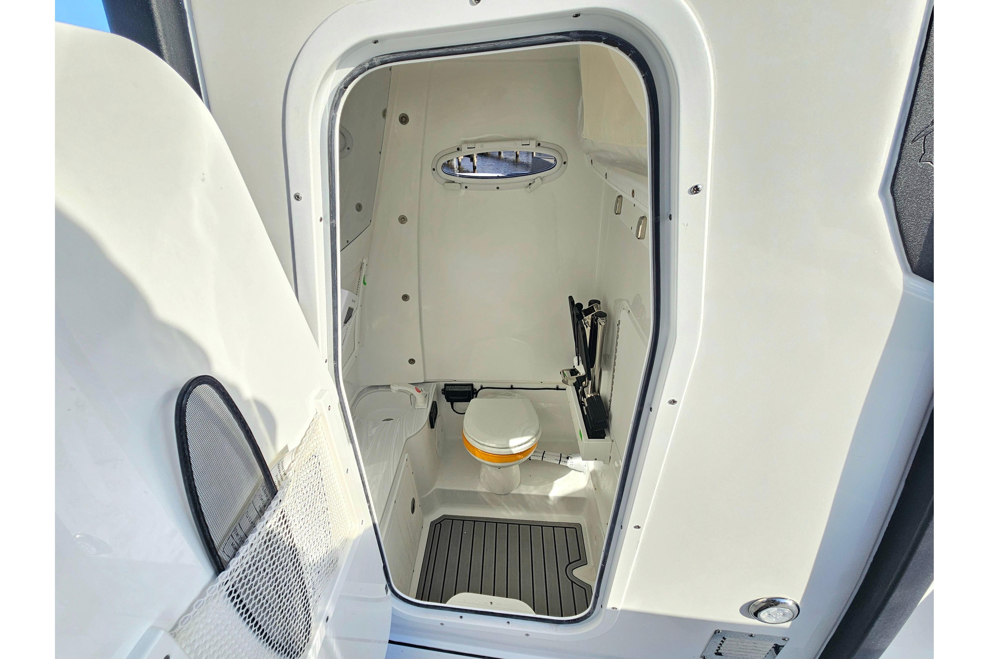 2026 Sea Hunt Ultra 285 SE boat interior with compact marine toilet and storage.