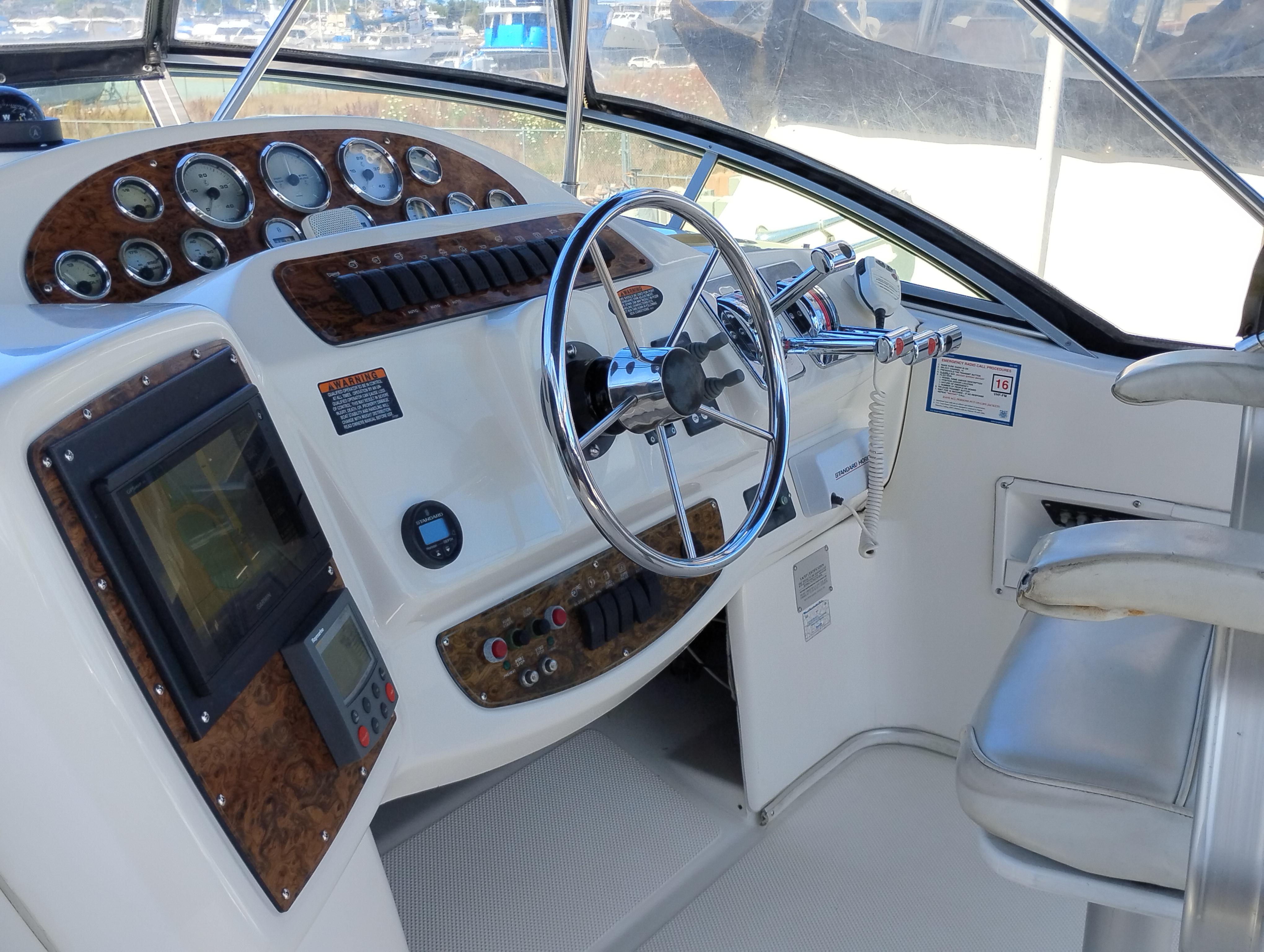 2001 Bayliner 3488 Command Bridge Motoryacht helm with steering wheel and control panel.