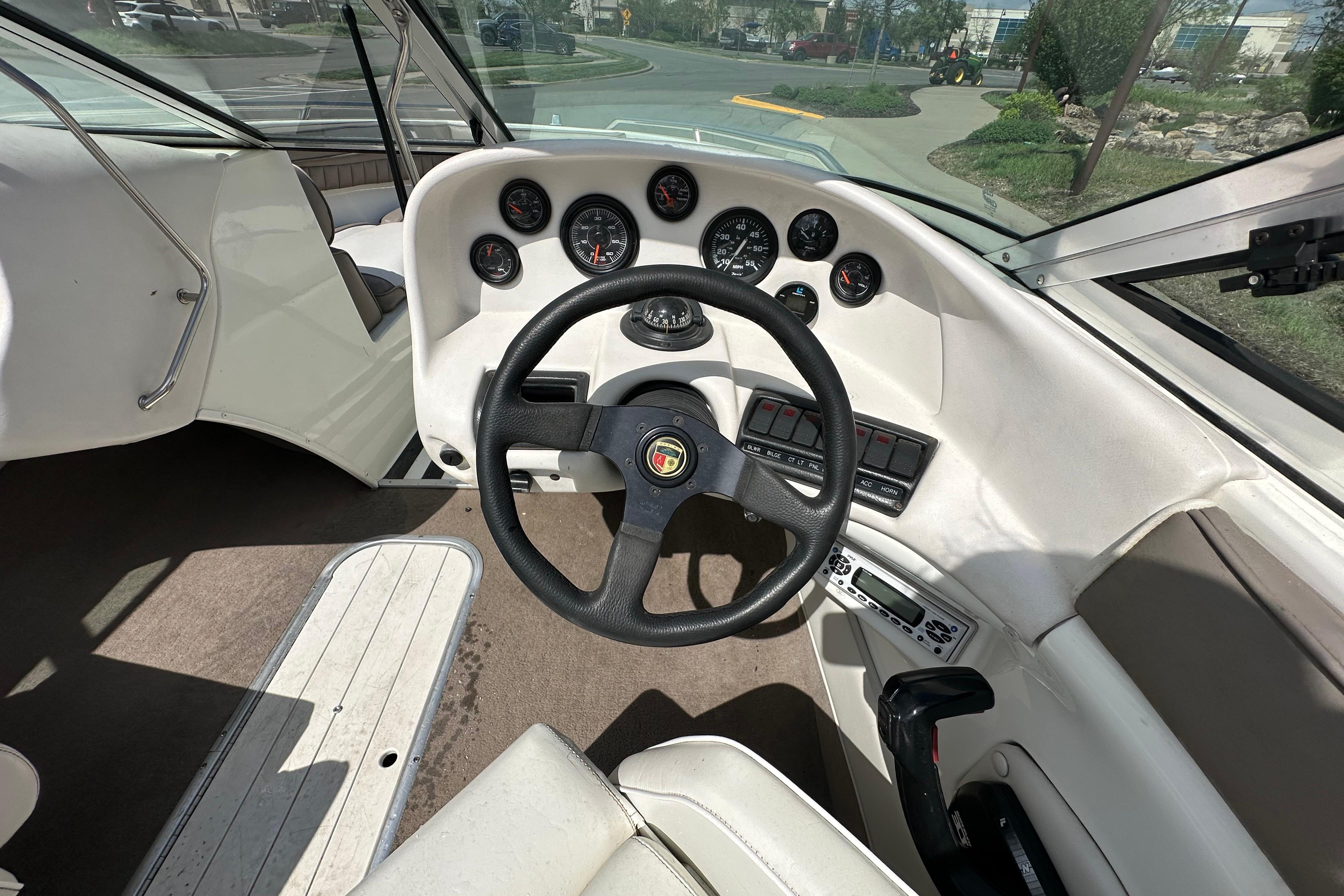 Interior view of a 1995 Mariah 180 Shabah boat dashboard with steering wheel and gauges.