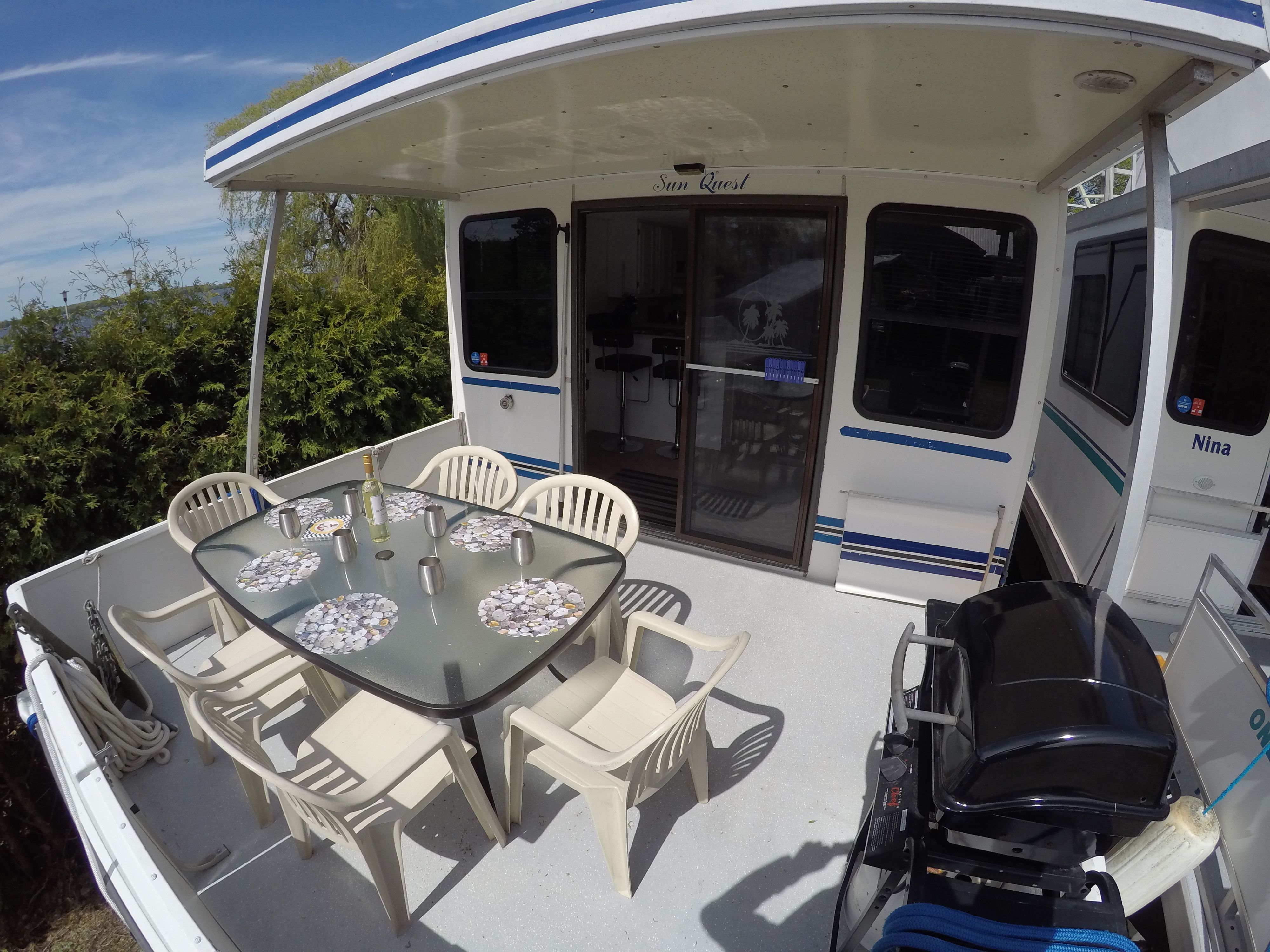A spacious deck with a table and chairs on a 2004 42 ft Catamaran.