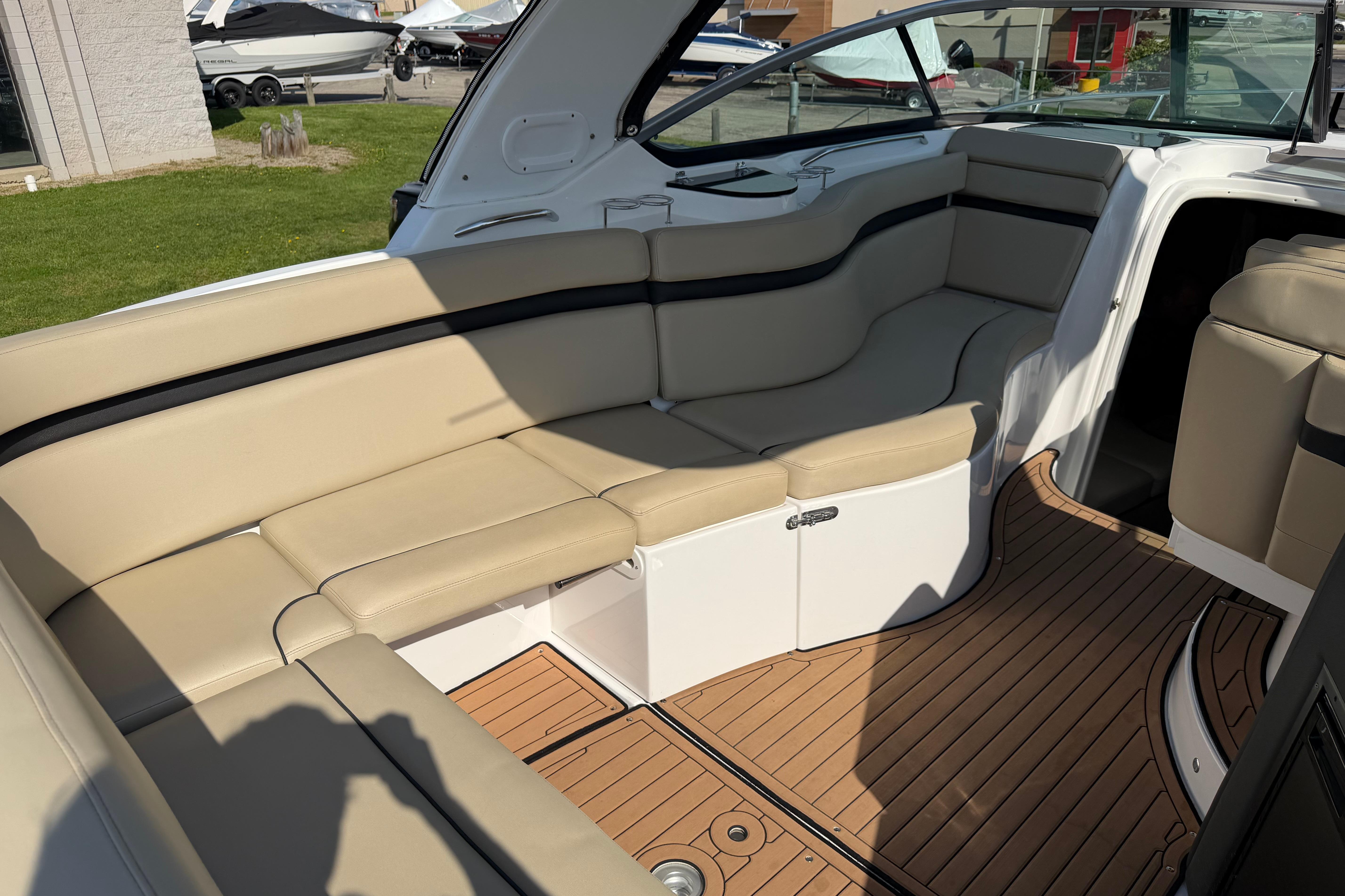 2019 Rinker EX 320 boat interior with beige seating and teak flooring.