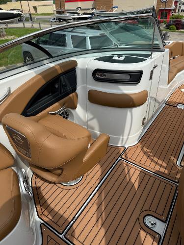2025 Crownline 290 SS boat interior with tan seating and wood-style flooring.
