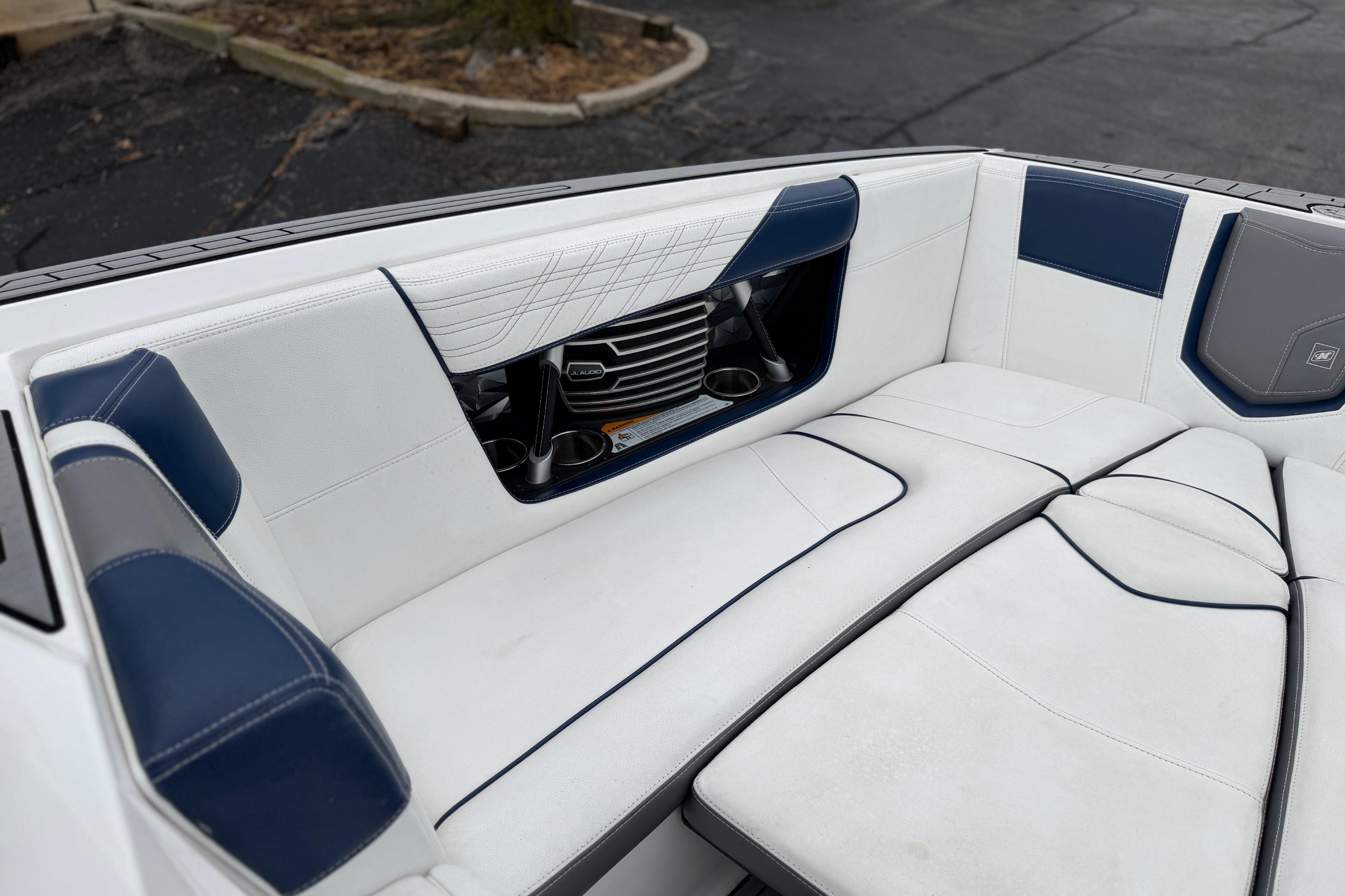 2016 Naitique G25 boat interior with white and blue seating, cup holders, and speaker.