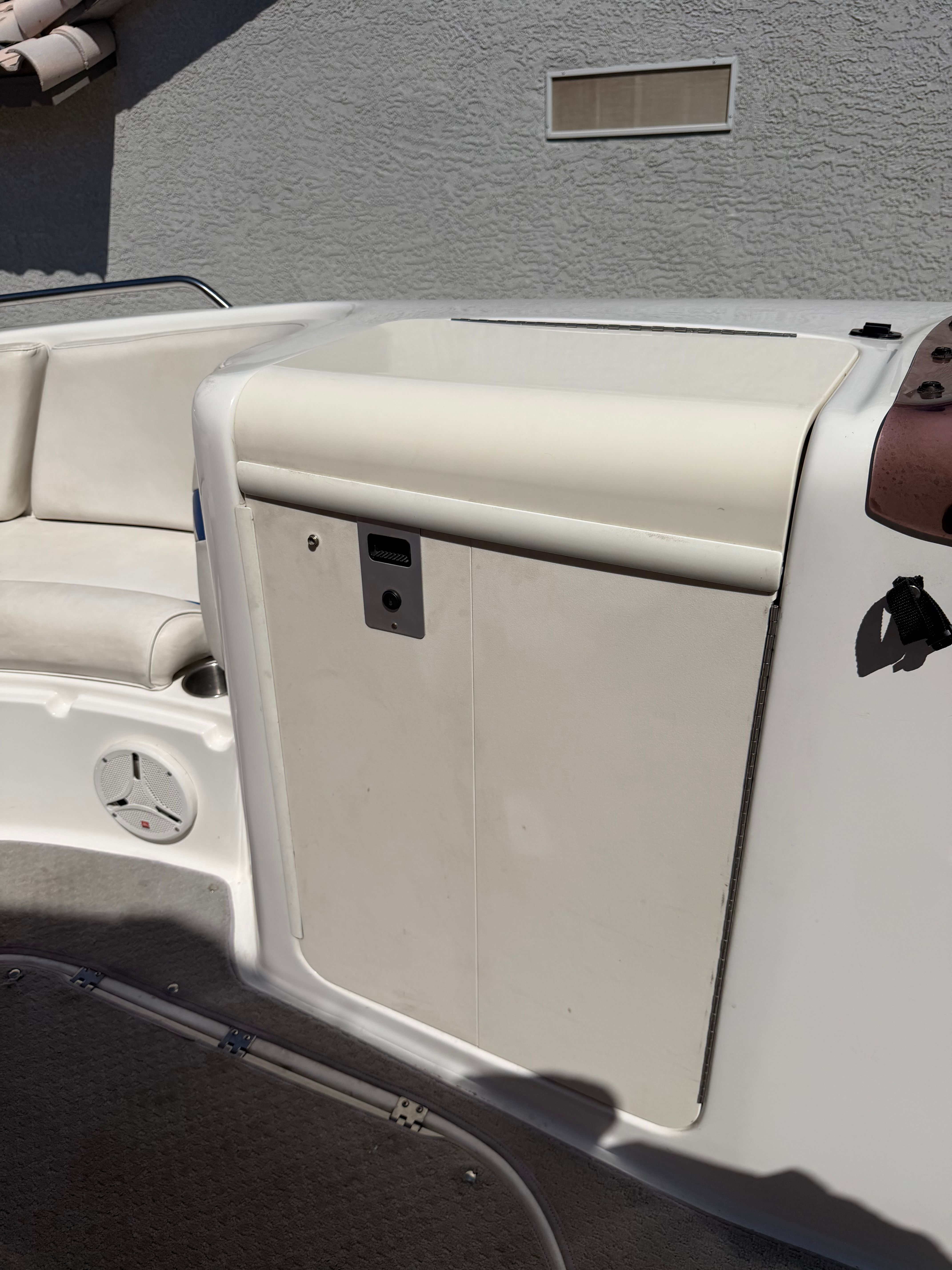 Close-up of a boat's interior with white seating and a control panel.