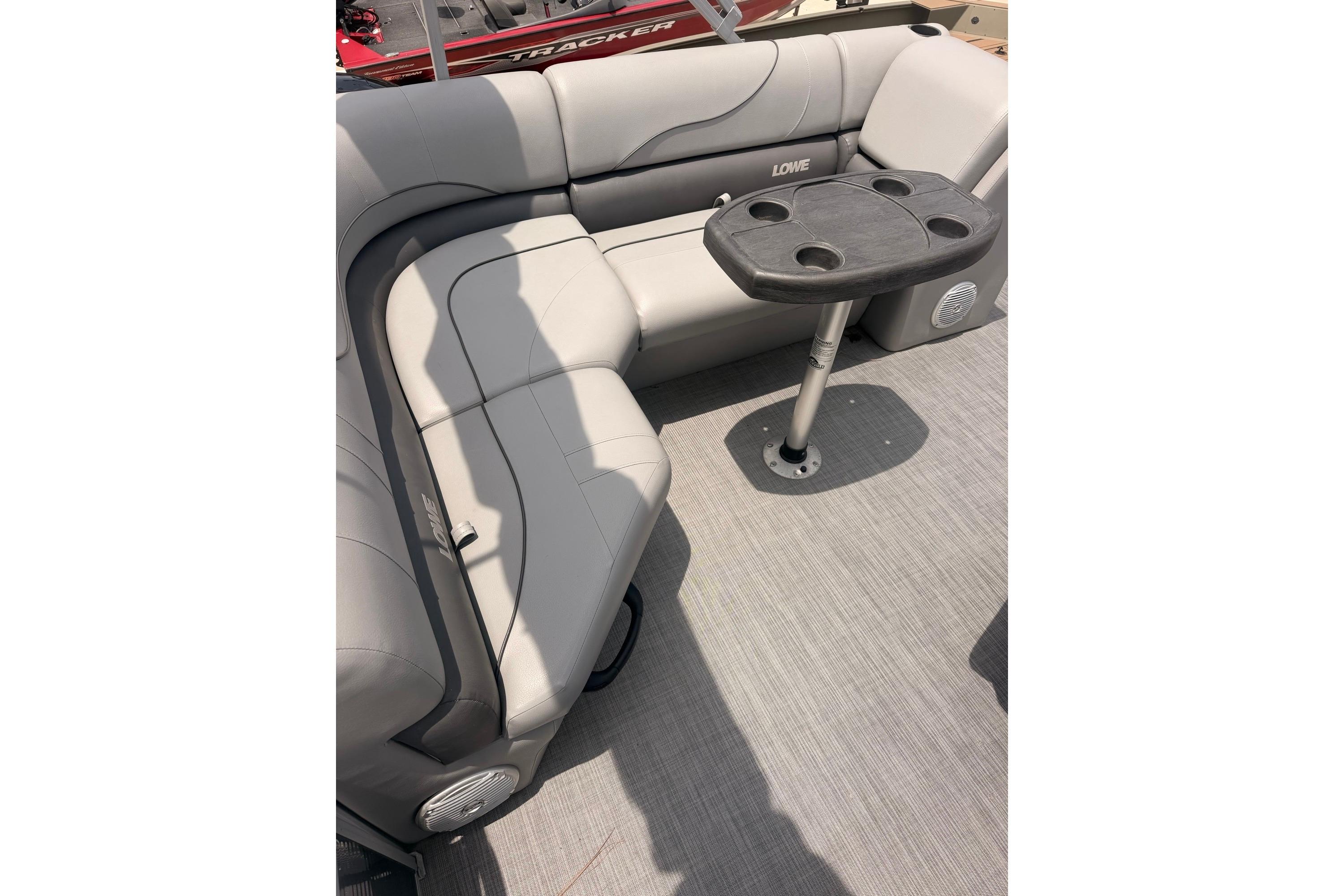 2021 Lowe SS 210 boat interior with gray seating and a small table.