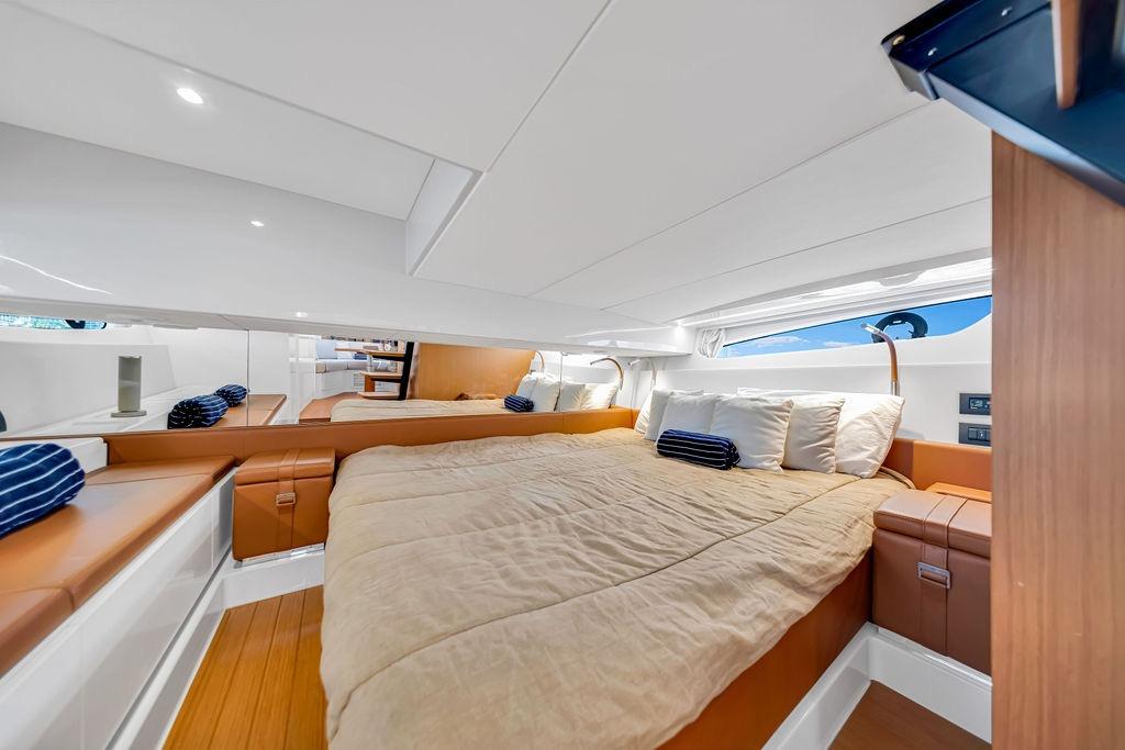 Luxurious cabin interior of 2021 Bluegame BG 42 yacht with cozy bedding and modern design.