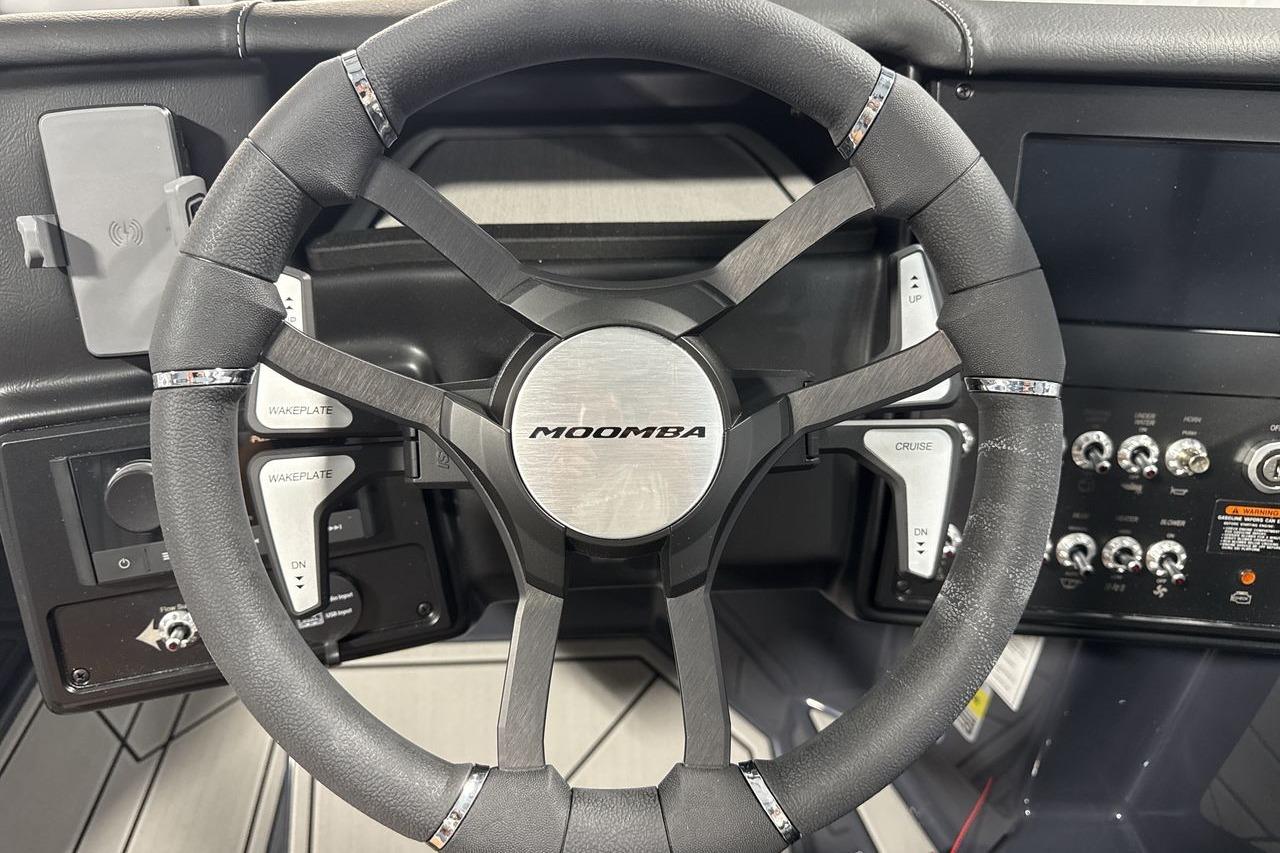 Steering wheel of a Moomba Craz boat with controls and dashboard.