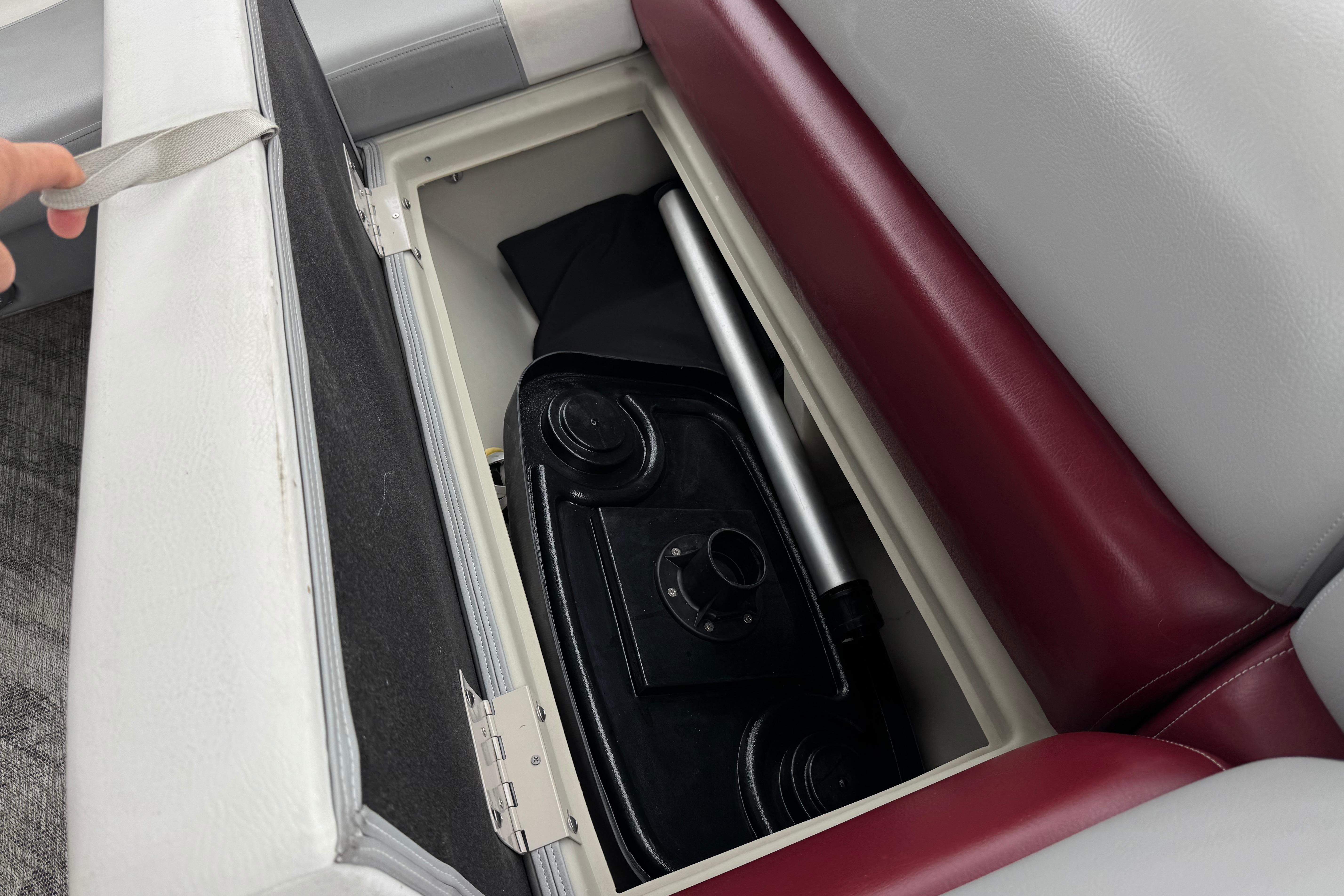Storage compartment in 2020 Manitou 18 Aurora LE boat with seat cushion lifted.
