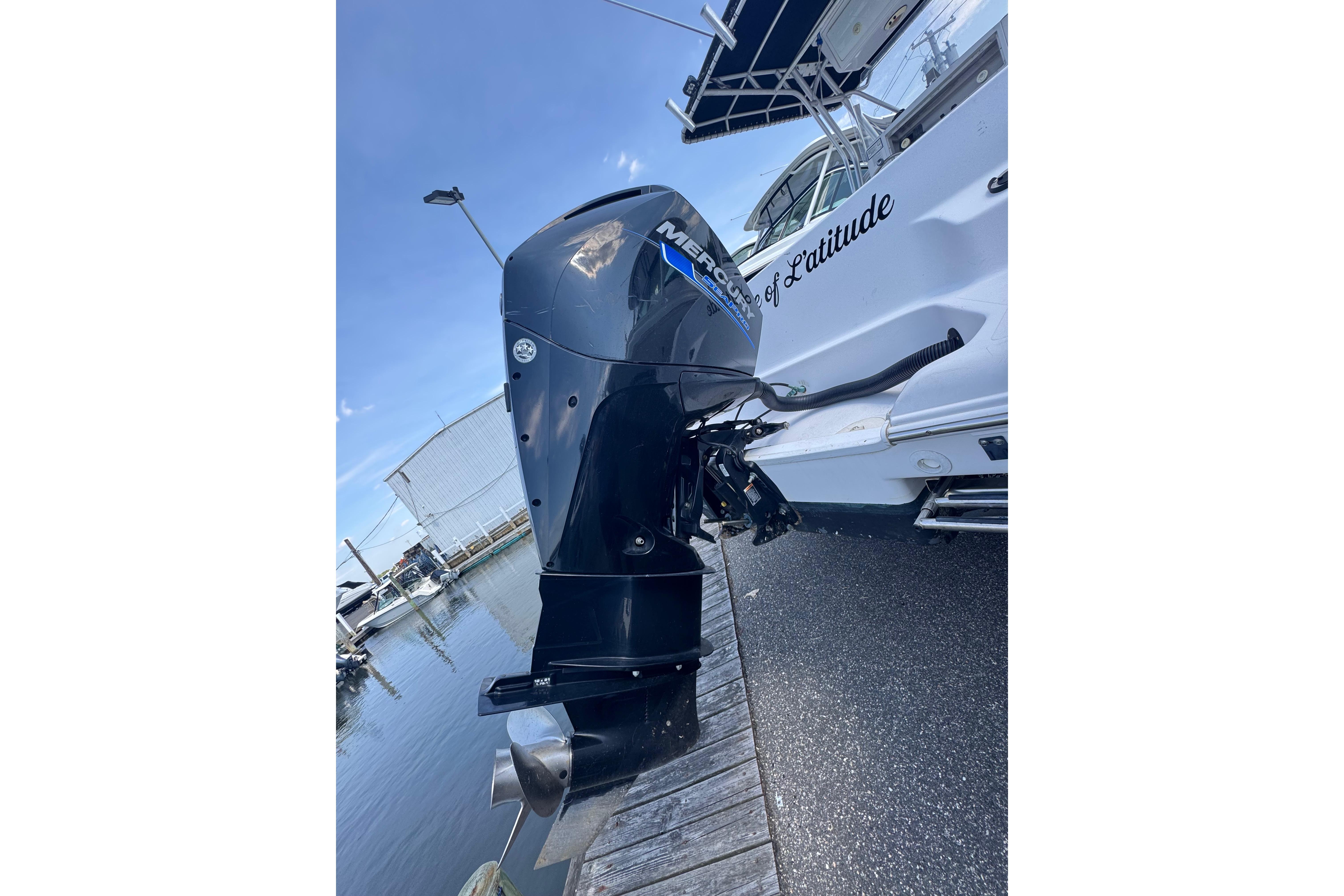 2002 Pro-Line 23 Sport boat with Mercury outboard motor docked at marina.