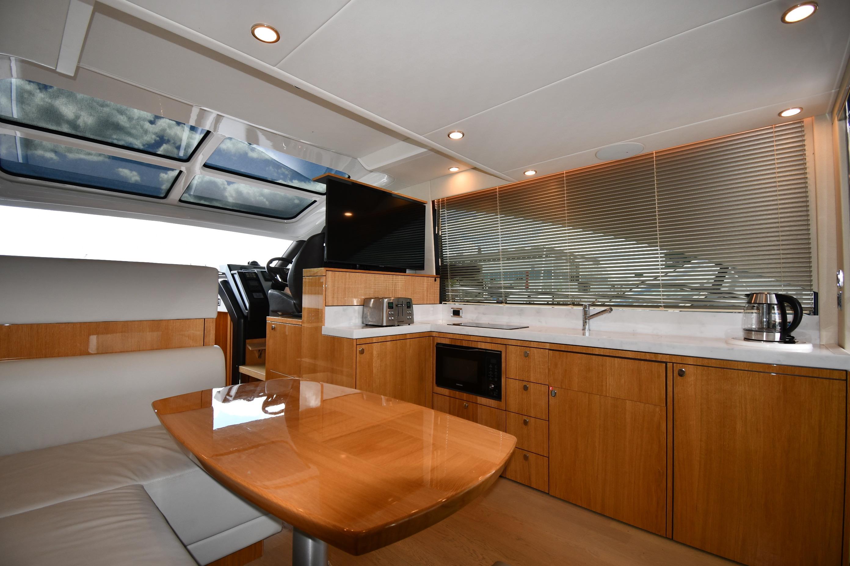 Luxurious interior of 2024 Fairline G50 Targa yacht with modern kitchen and seating area.